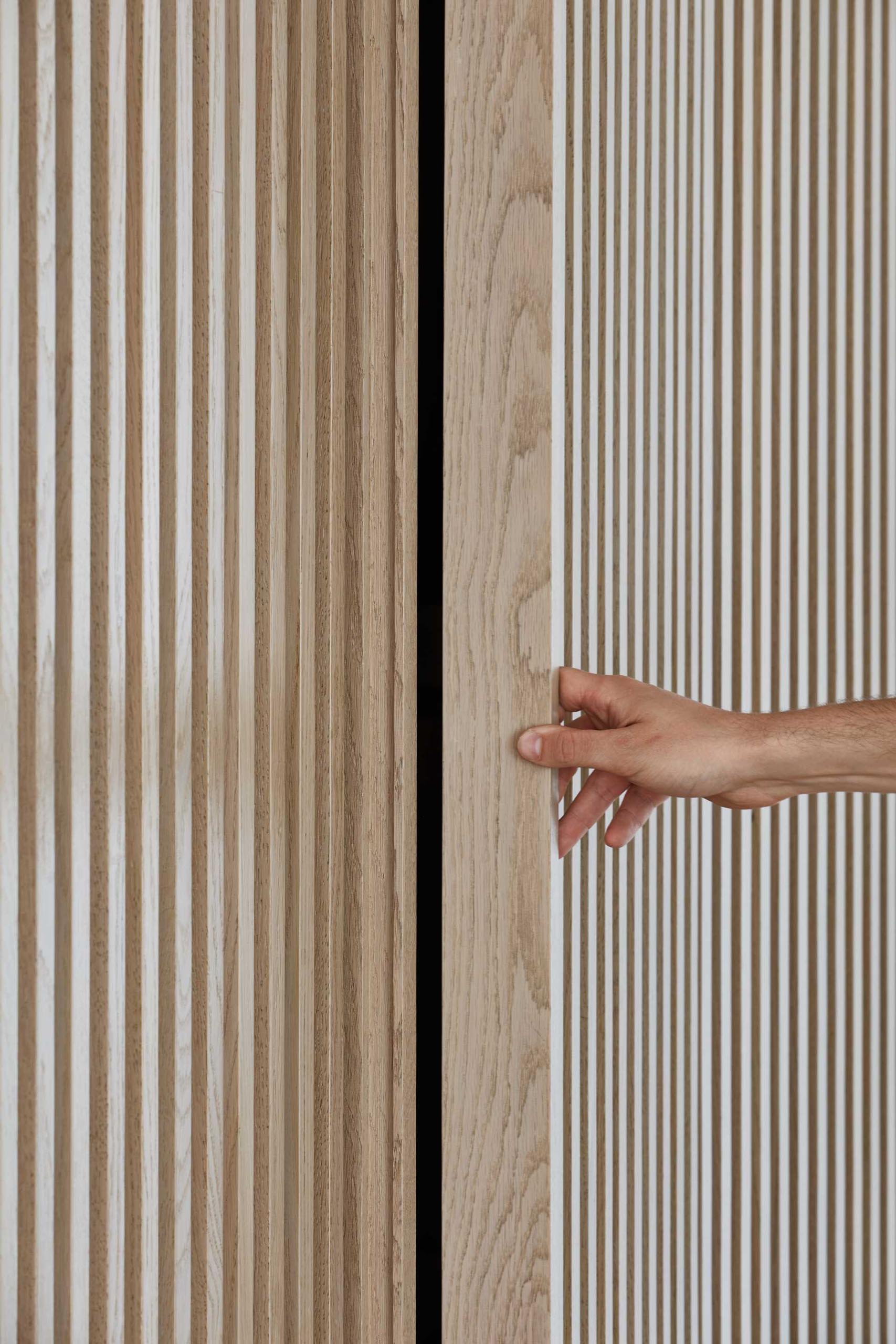 A wood slat wall hides storage within.