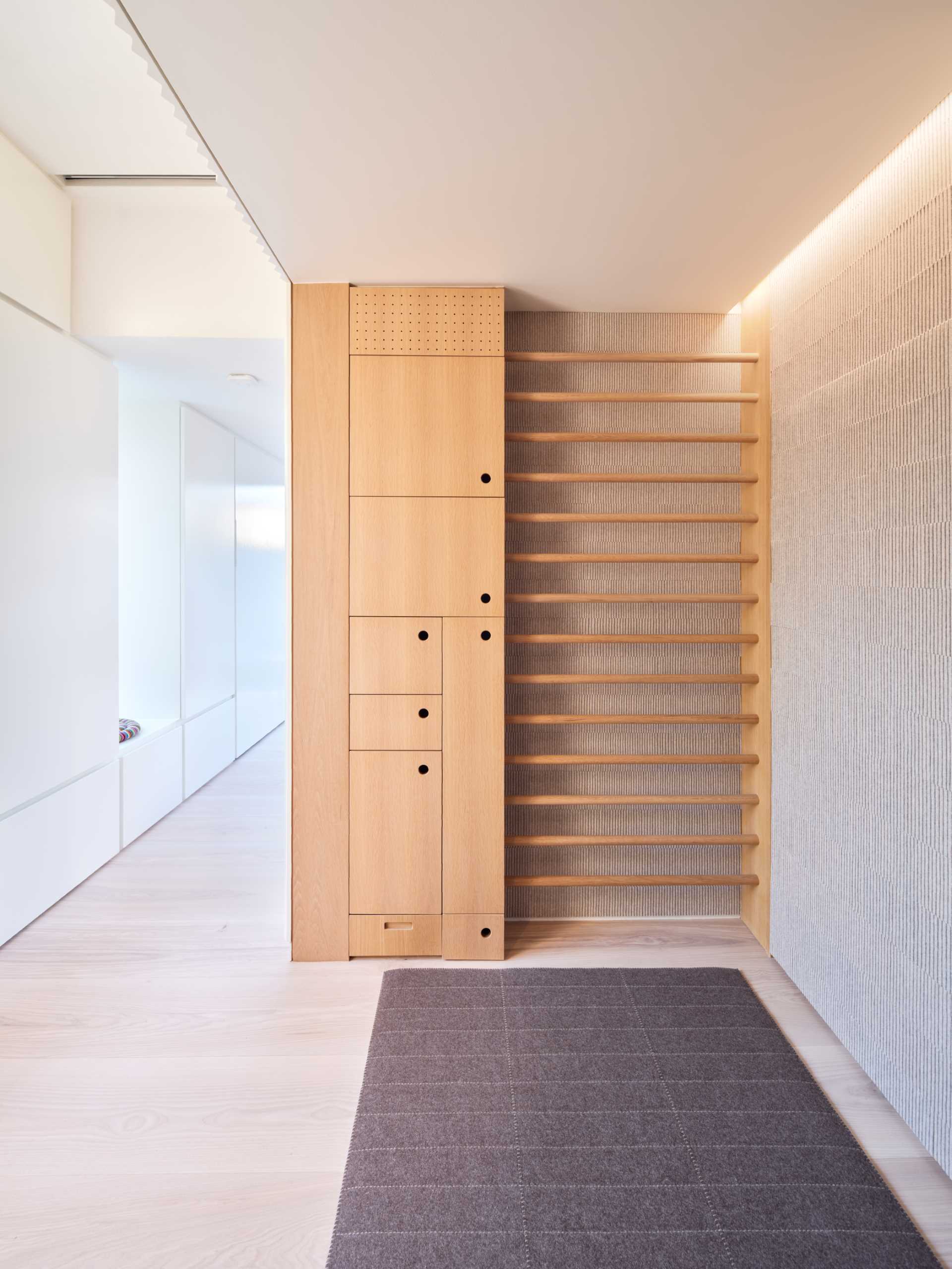 A wellness room for stretching and meditation, that's lined with softly ridged millwork that conceals storage cabinet to accommodate yoga equipment.