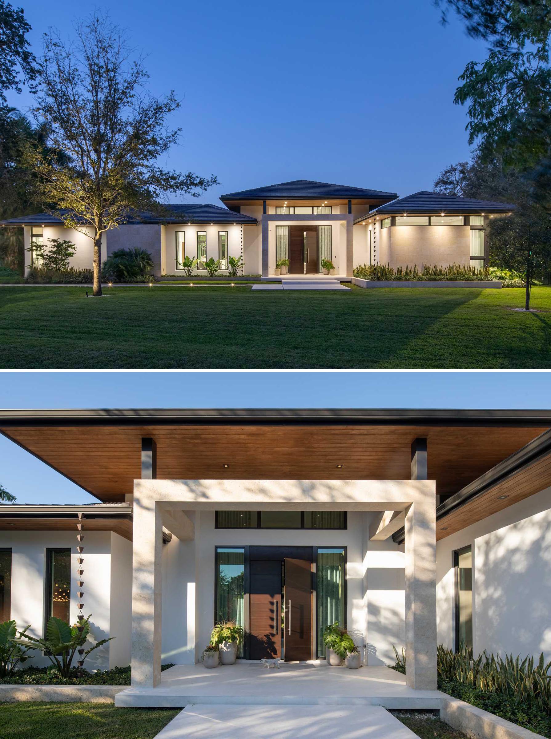 The front of this house was designed with a large lawn that has a path leading to the front door. Plants and lighting soften the exterior of the home, while rain chains add a sculptural element.