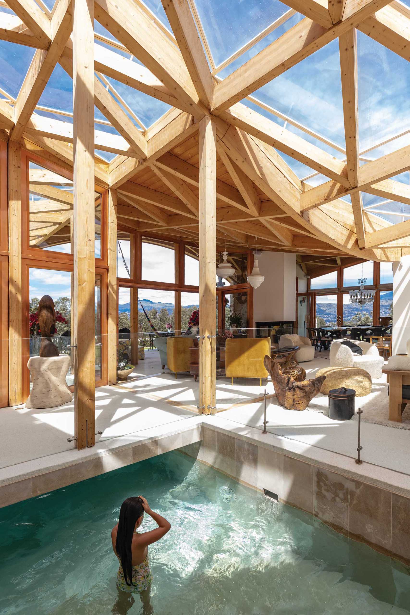 A unique design element in this wooden house is the indoor swimming pool that has windows in the roof structure above it, making it feel like it's outdoors.