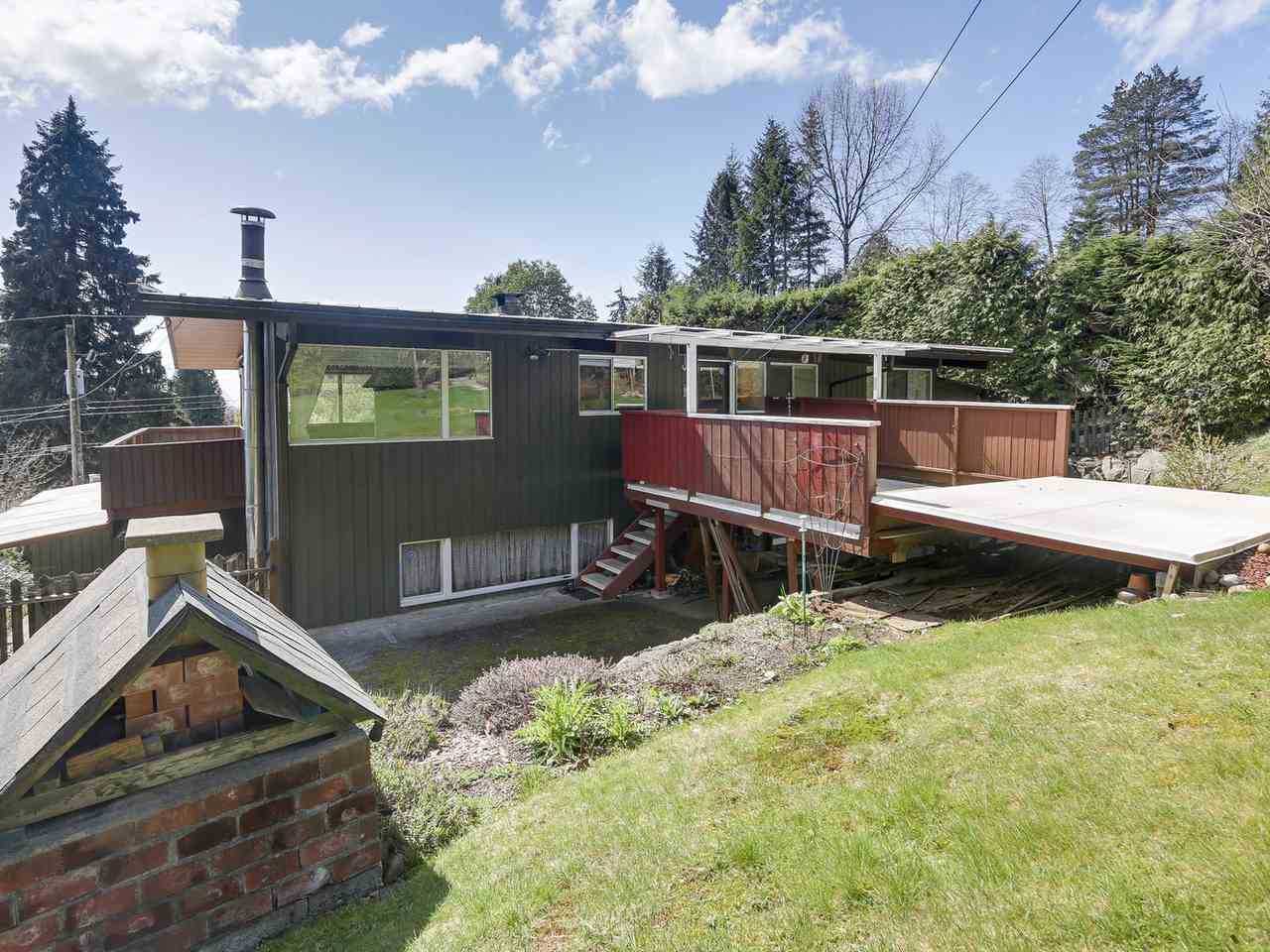 BEFORE - A dated mid-century modern house with rear wood deck.