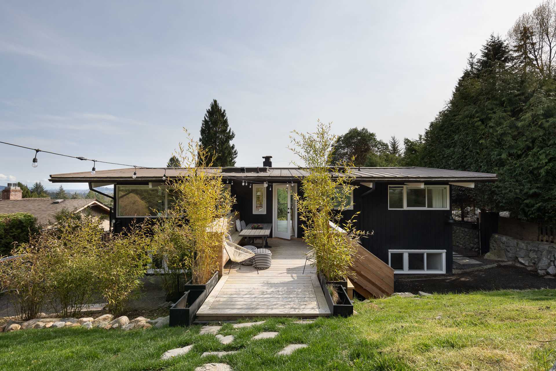 The new deck of this remodeled home, is made from Cedar and allows the kitchen to lead directly to the outdoor patio area, which has been furnished with a dining area. 