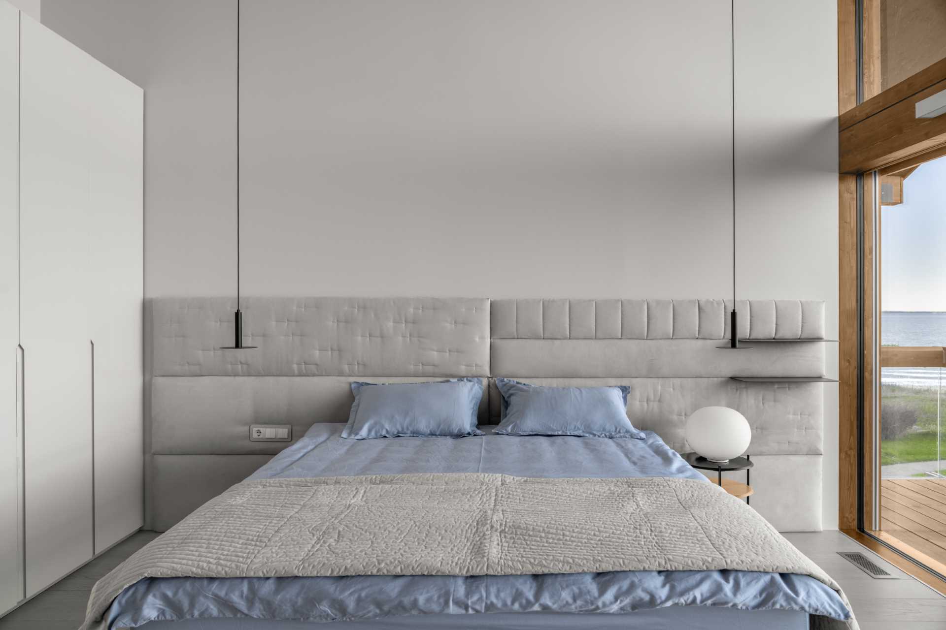 A modern baedroom with a gray, white, and blue theme.