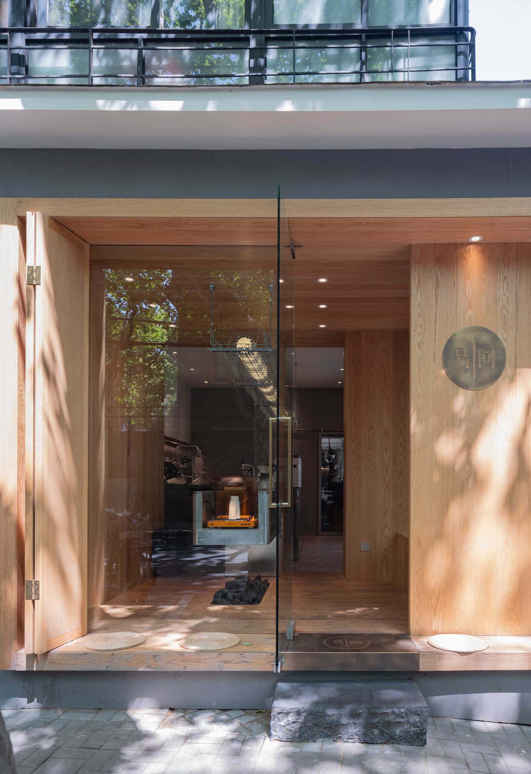 A modern coffee shop with a wood facade, opens to the street.