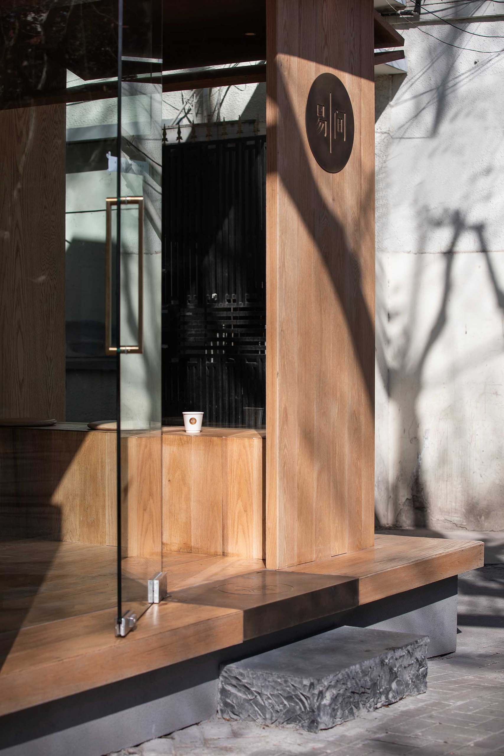 A modern coffee shop with a wood facade that includes bench seating.