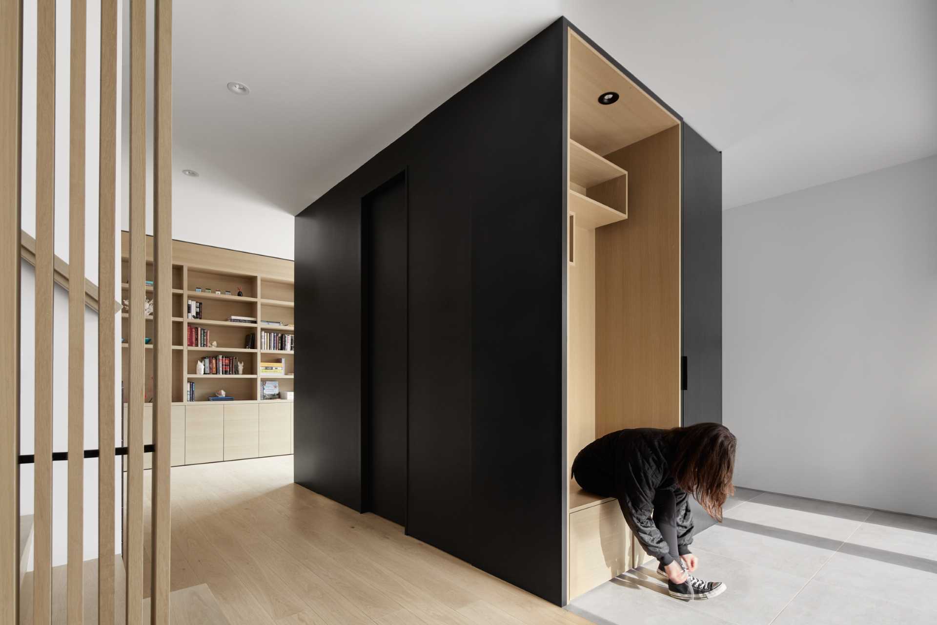 Stepping inside this modern farmhouse, and there's an entryway with a small wood-lined bench area.