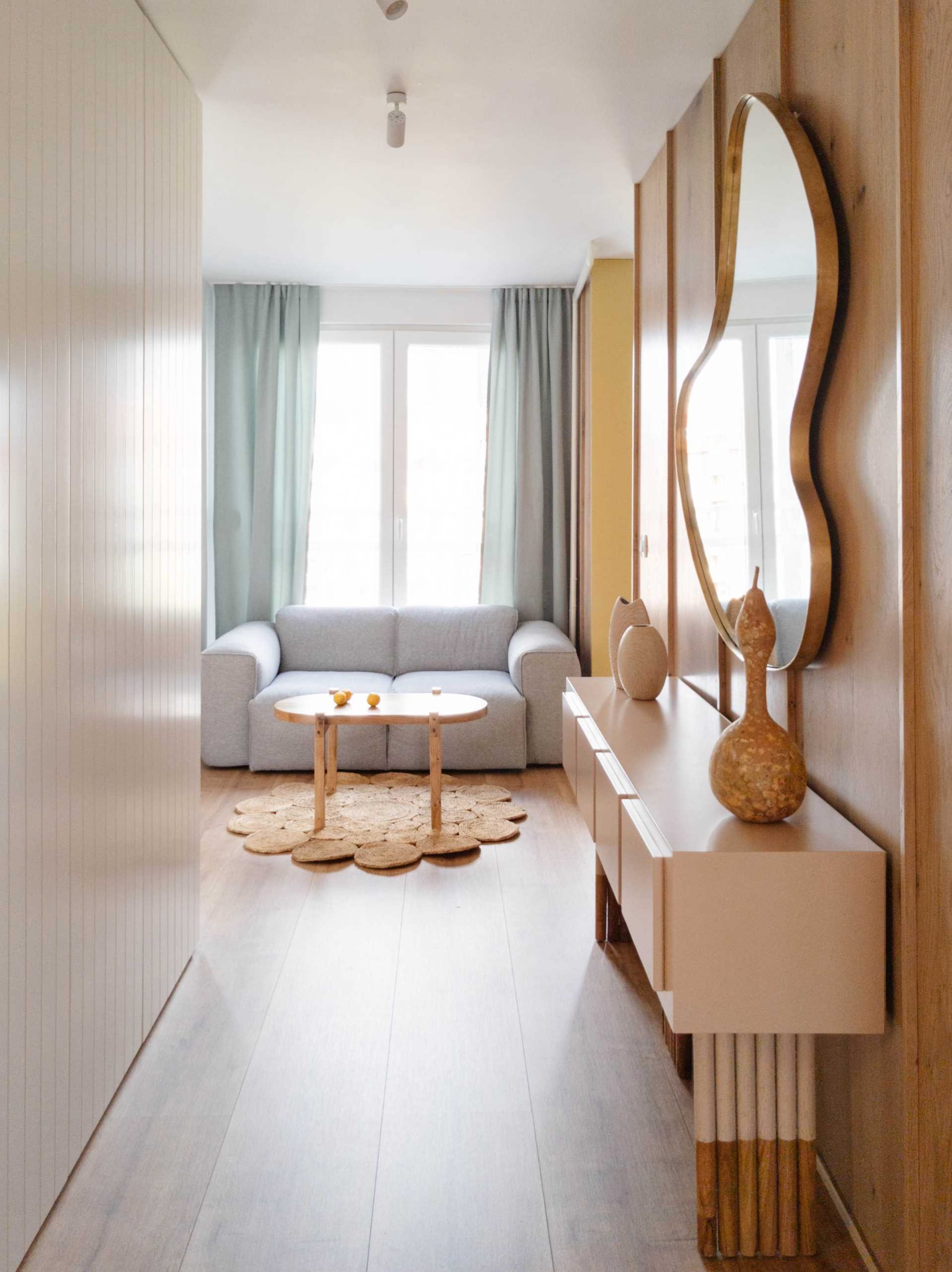In this hallway, a wood accent wall as well as an abstract mirror and console have been added.