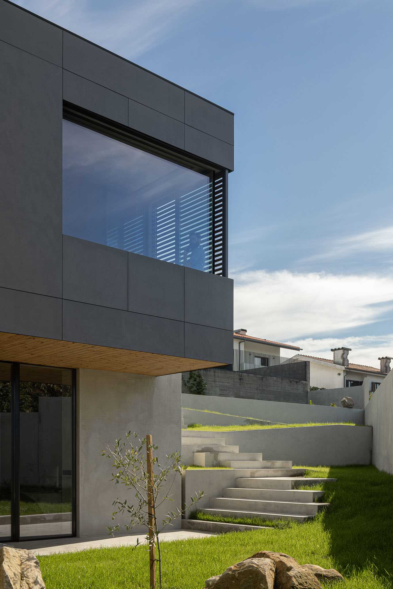 A modern landscaped yard with concrete stairs and retaining walls.