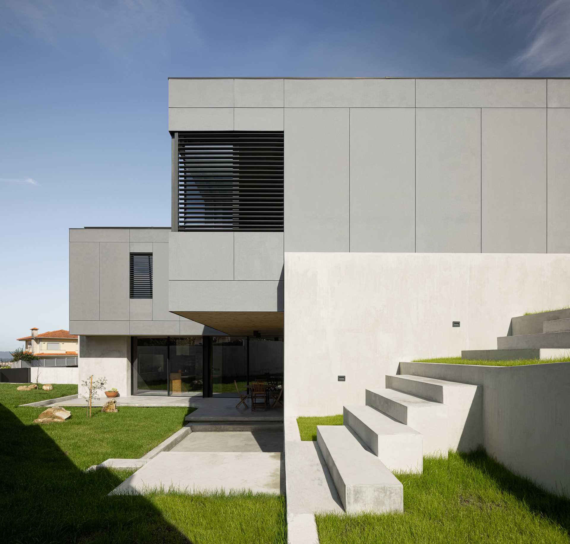 A modern landscaped yard with concrete stairs and retaining walls.