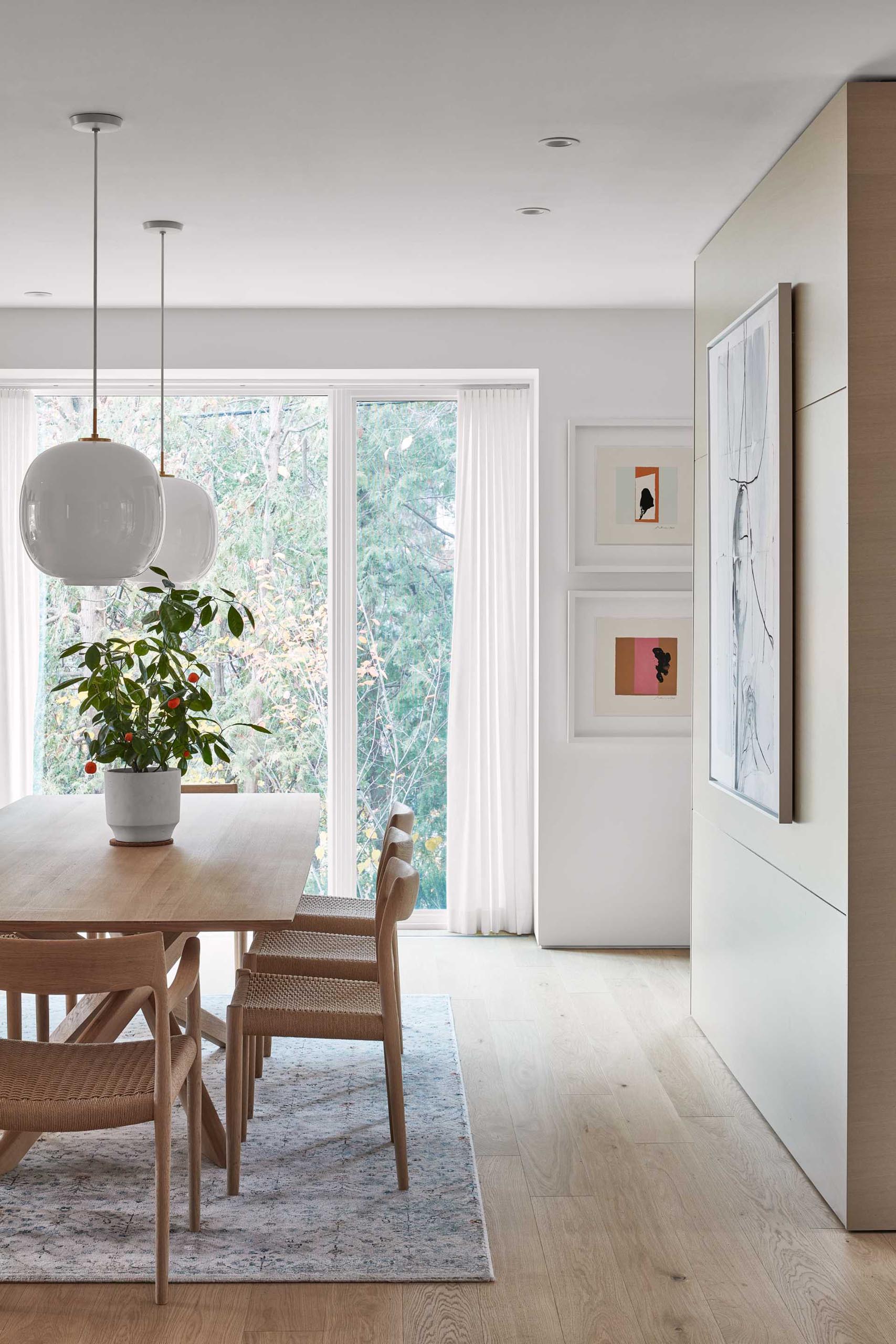 A modern dining room with a large wood table and matching chairs.