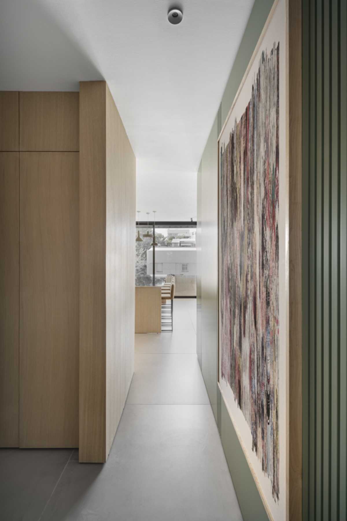 A hallway, that's been designed to match the green accent wall in the living room, leads to the bedrooms and bathrooms.