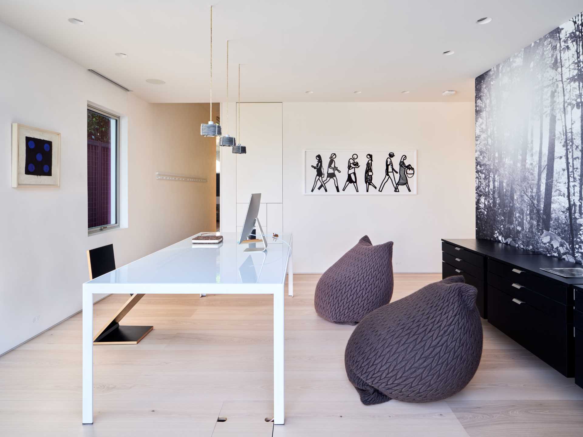 A modern home office with a white desk and contrasting wall mural.