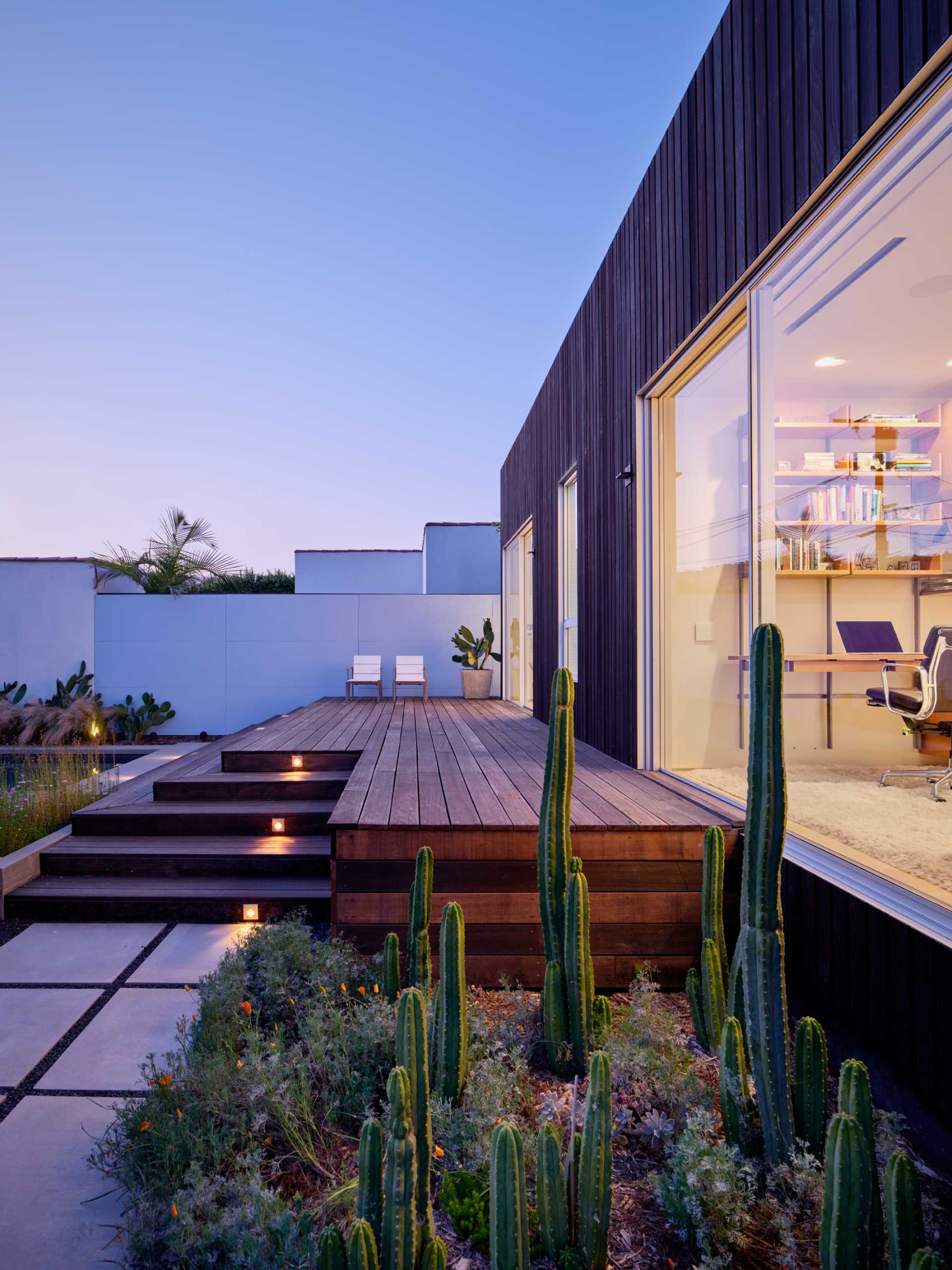 At the rear of the home, there's a wood deck and small dedicated planters that are filled with easy-to-care for plants.