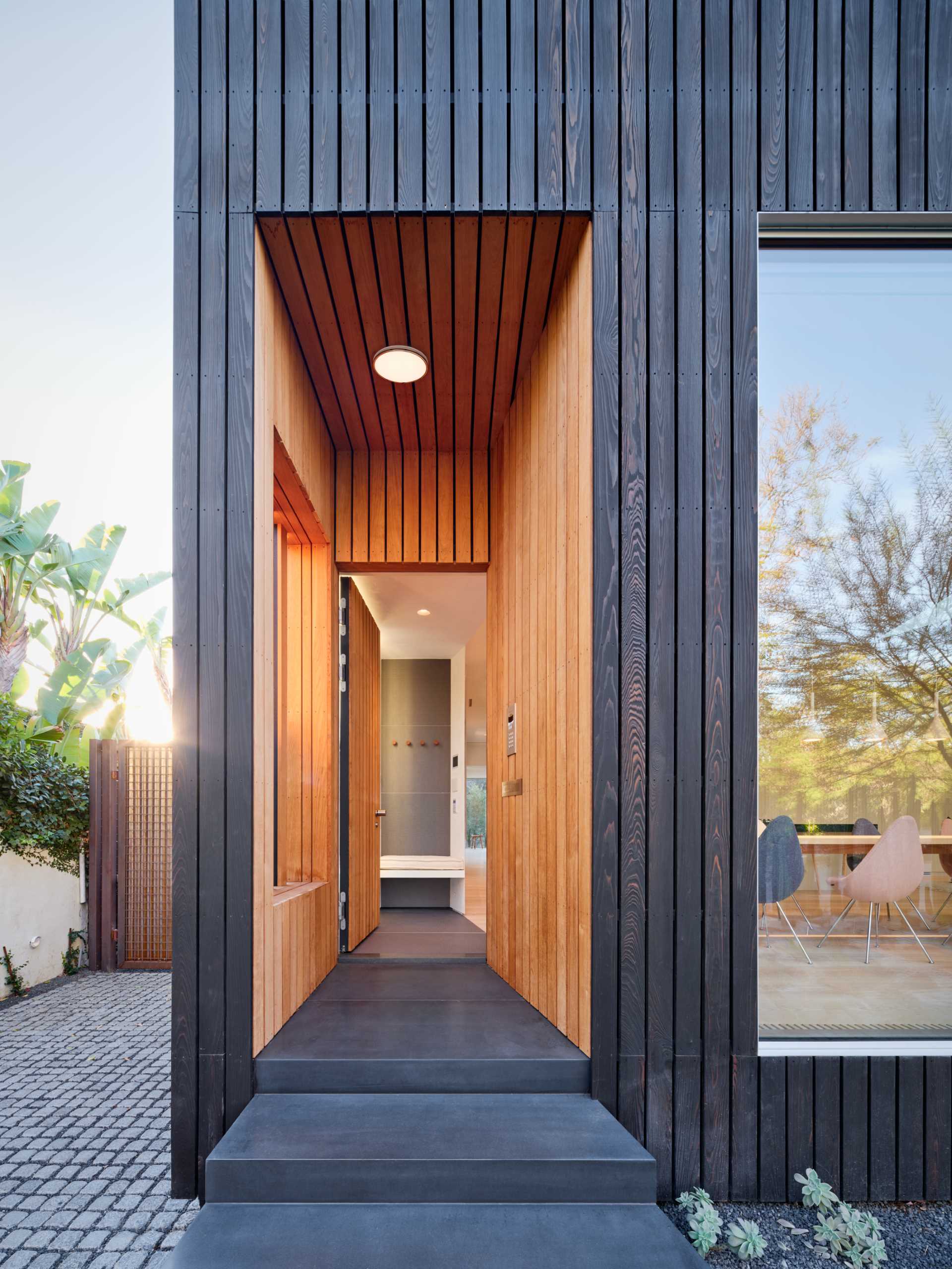 A modern house with a wood lined entry to match the front door.