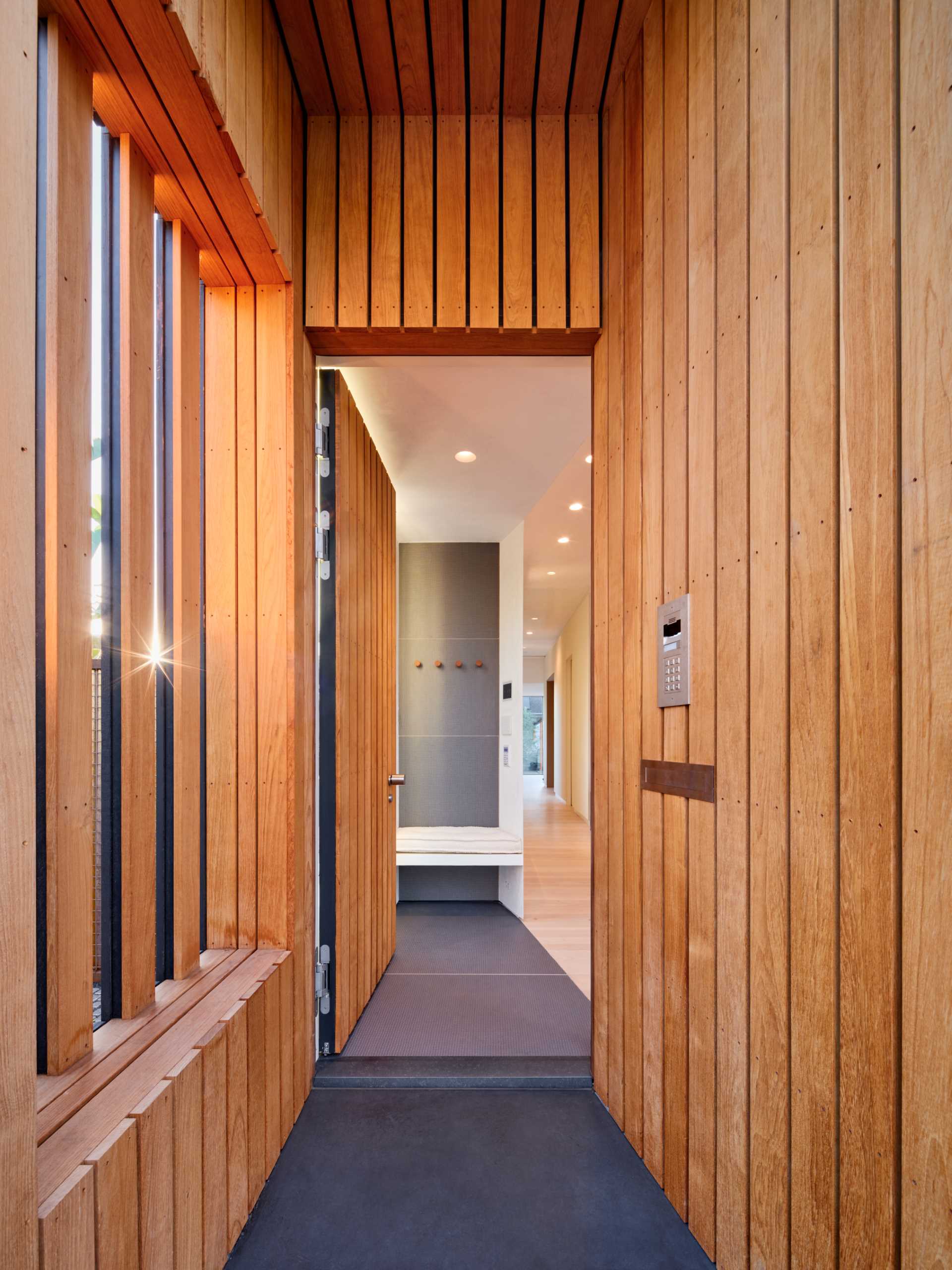 A modern house with a wood lined entry to match the front door.