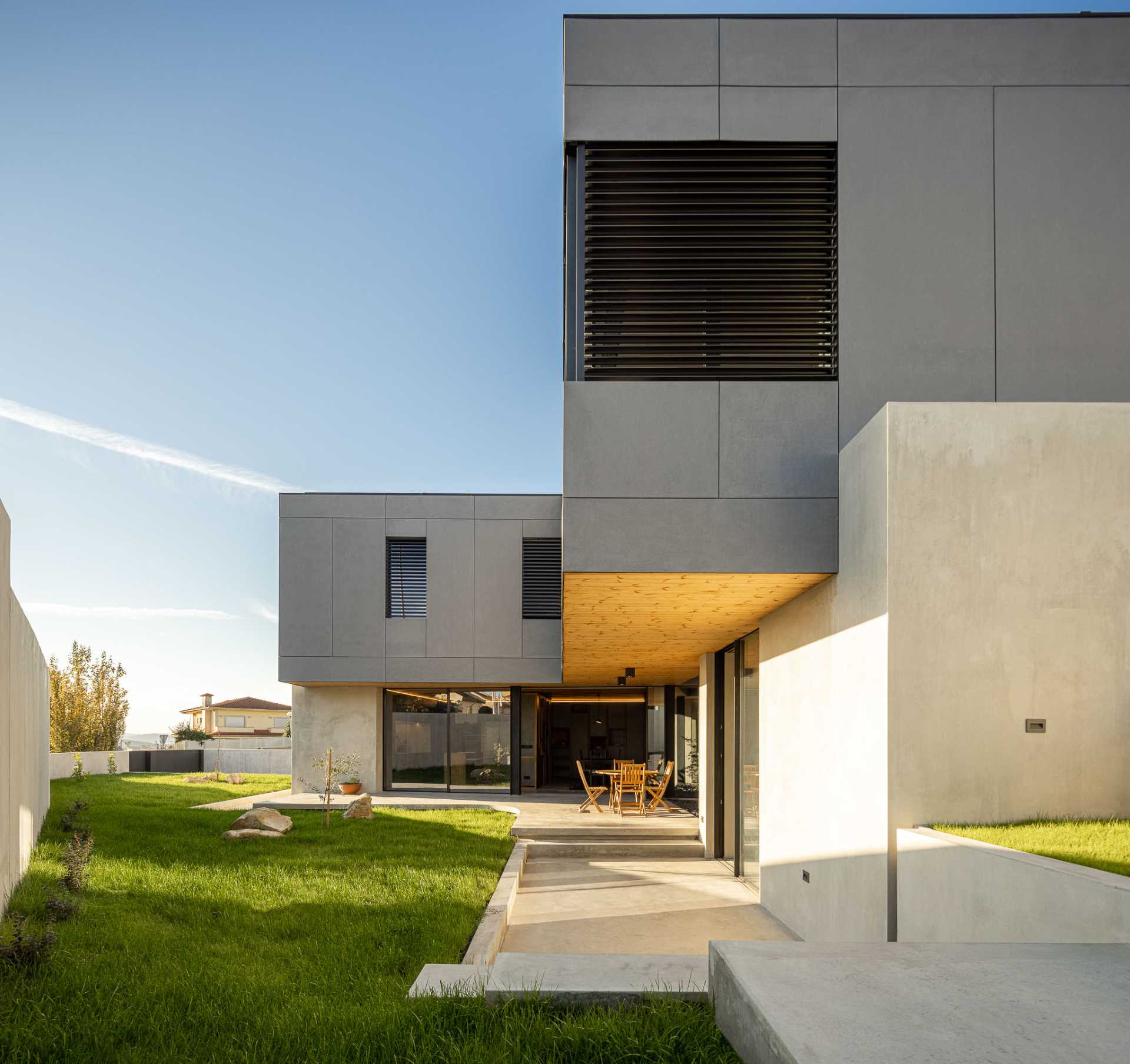 A modern concrete house with a curved patio.