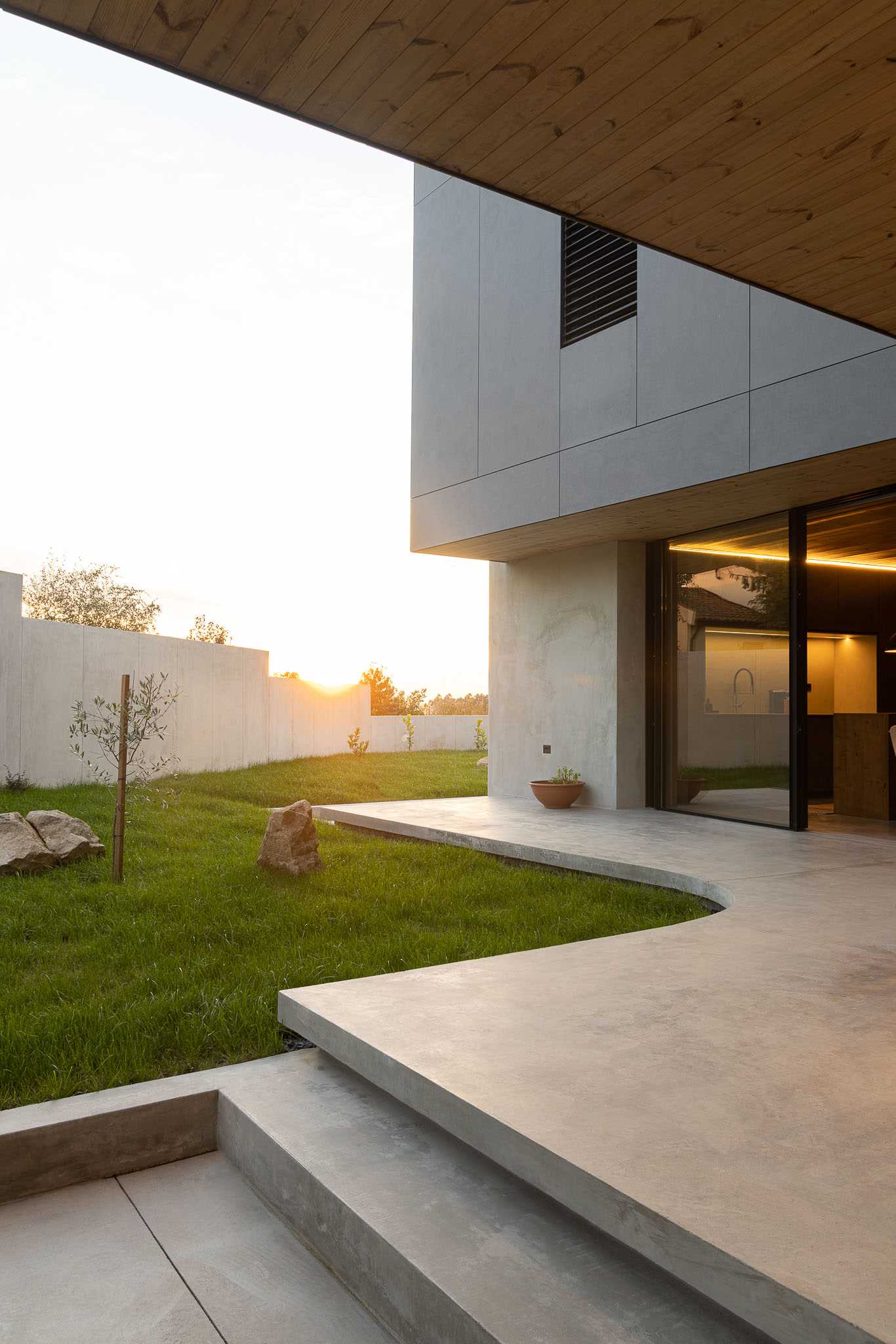 A modern concrete house with a curved patio.