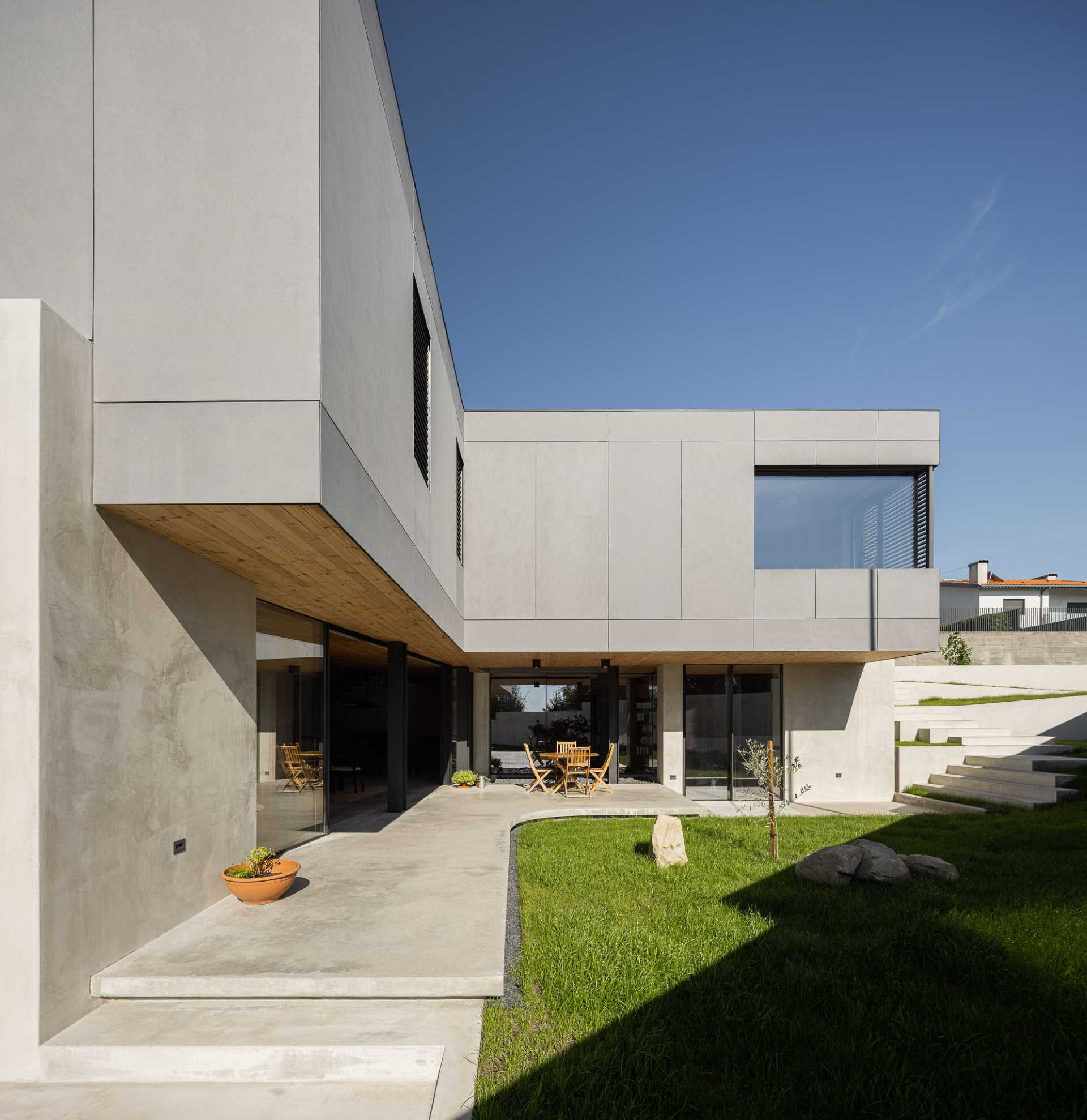 A modern concrete house with a curved patio.