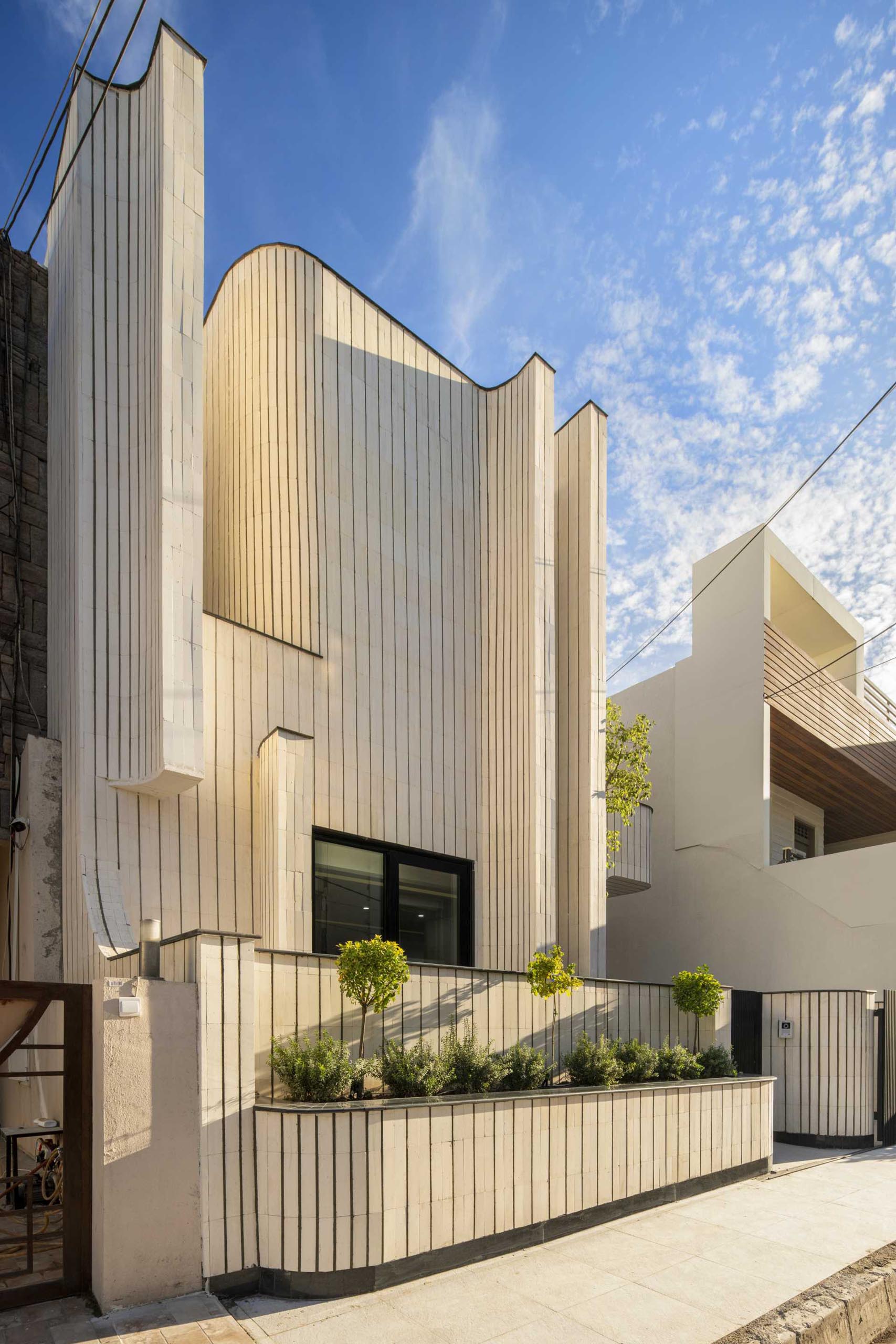 A modern house with a sculptural form and a built-in planter.