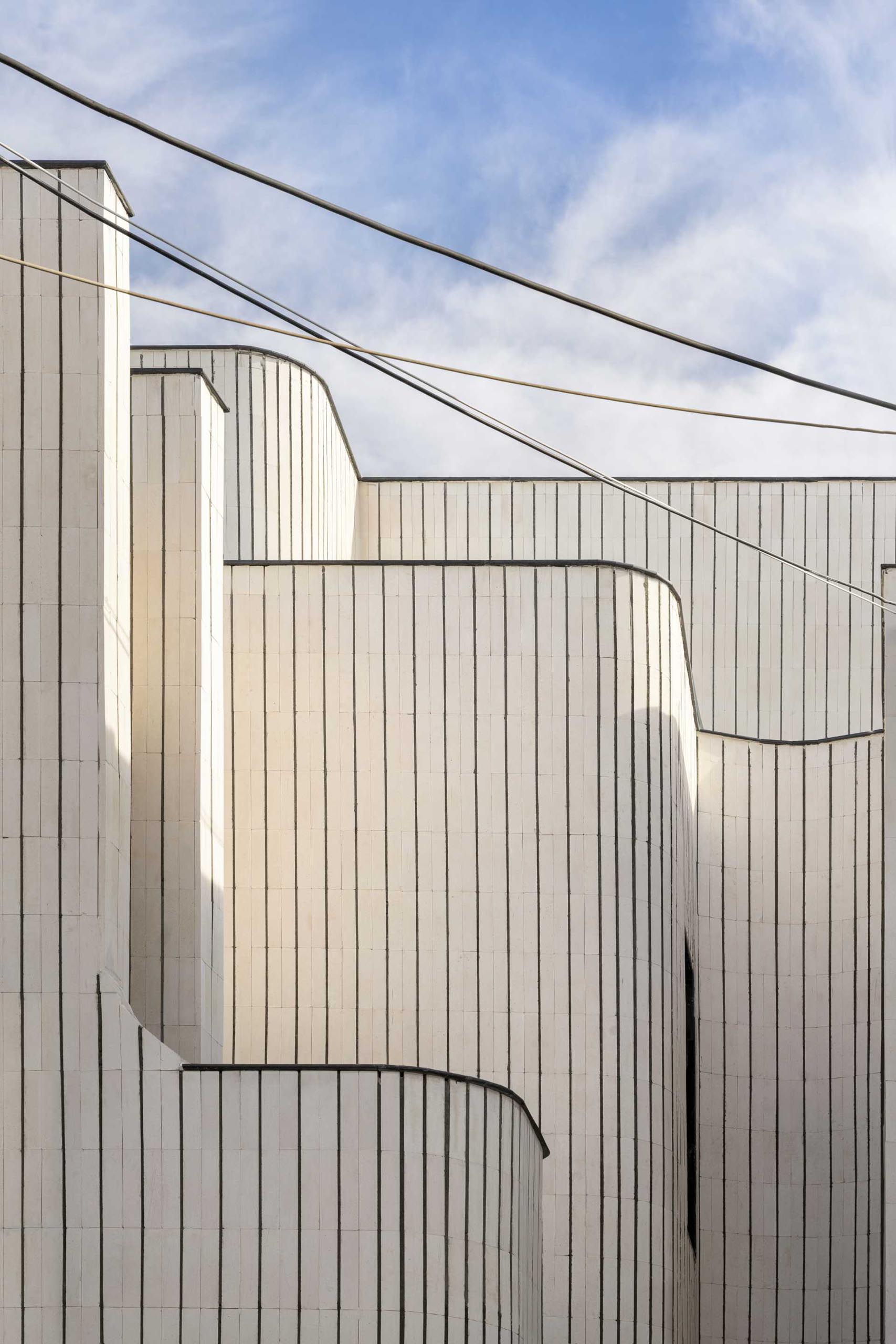 A modern house with sculptural curves covered in tiles.