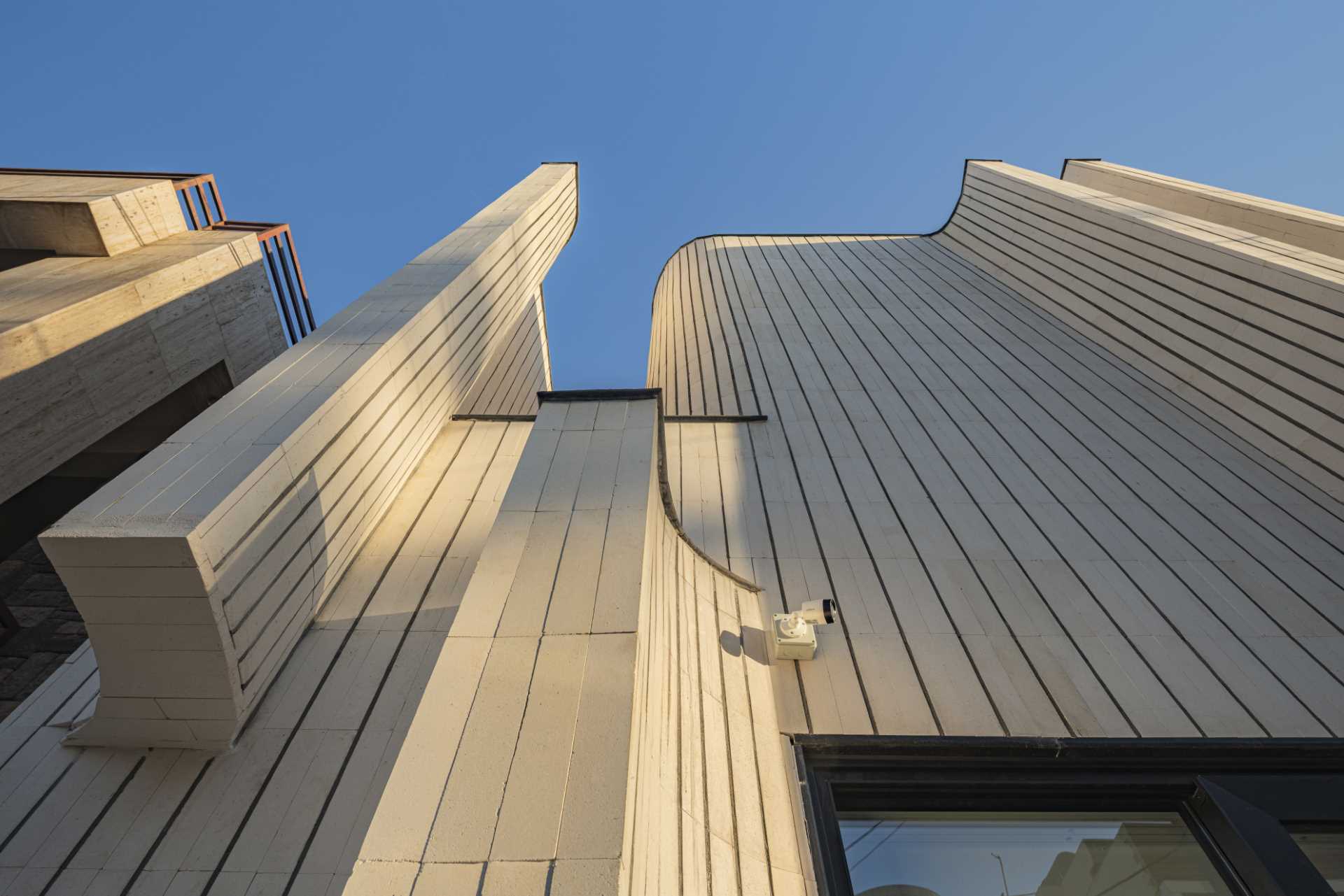 A modern house with tile facade and curves.