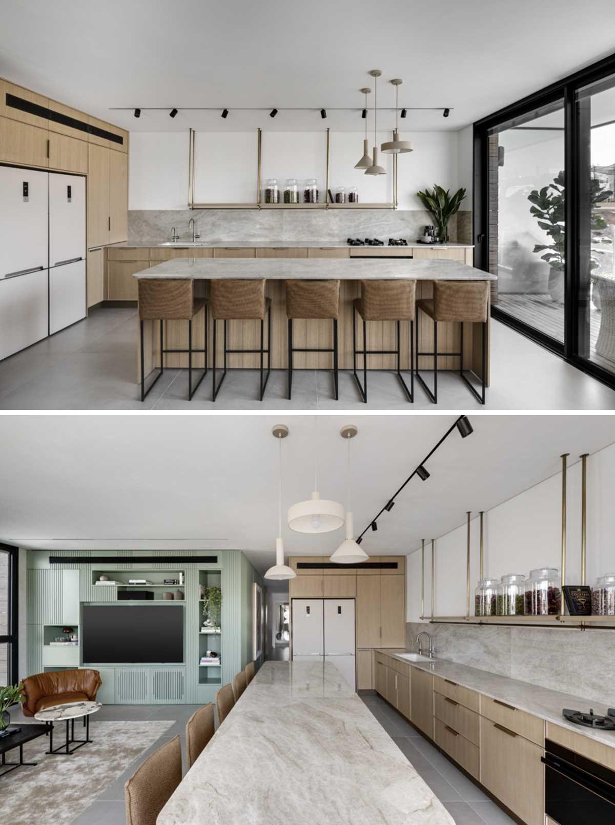 This modern kitchen with a natural clolor palette includes minimalist shelf hanging from the ceiling instead of upper cabinets, keeps the space feeling open, and offers the chance to display filled glass jars.