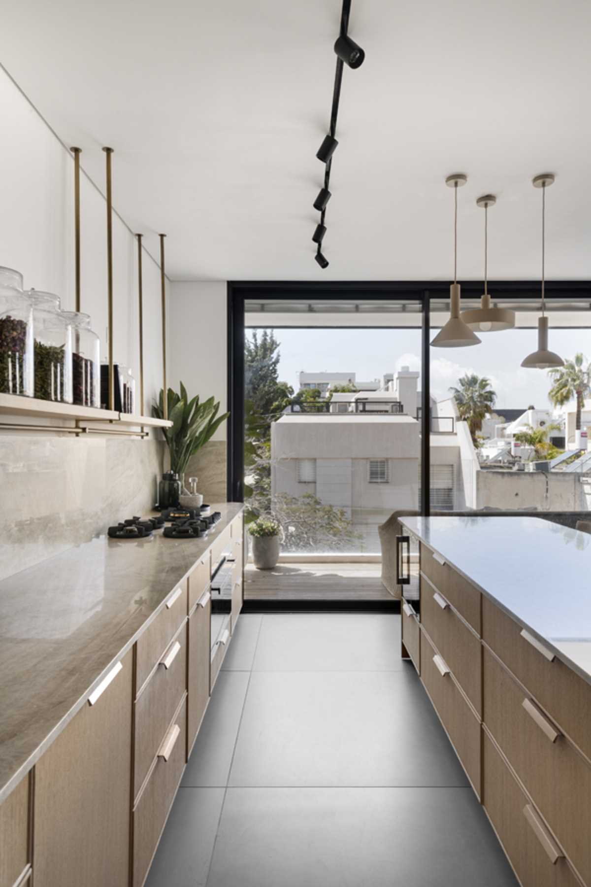 This modern kitchen includes a minimalist shelf hanging from the ceiling instead of upper cabinets, keeps the space feeling open, and offers the chance to display filled glass jars.