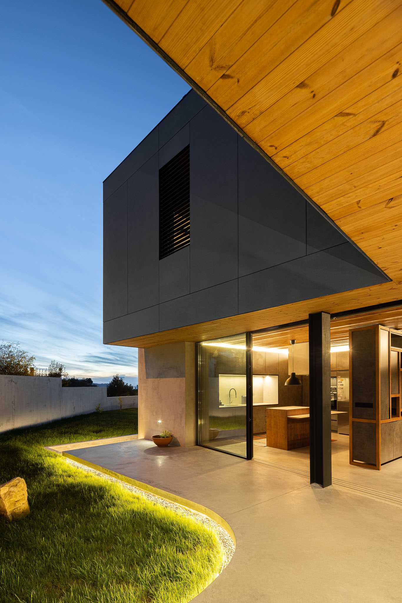 A modern curved concrete patio with hidden lighting.