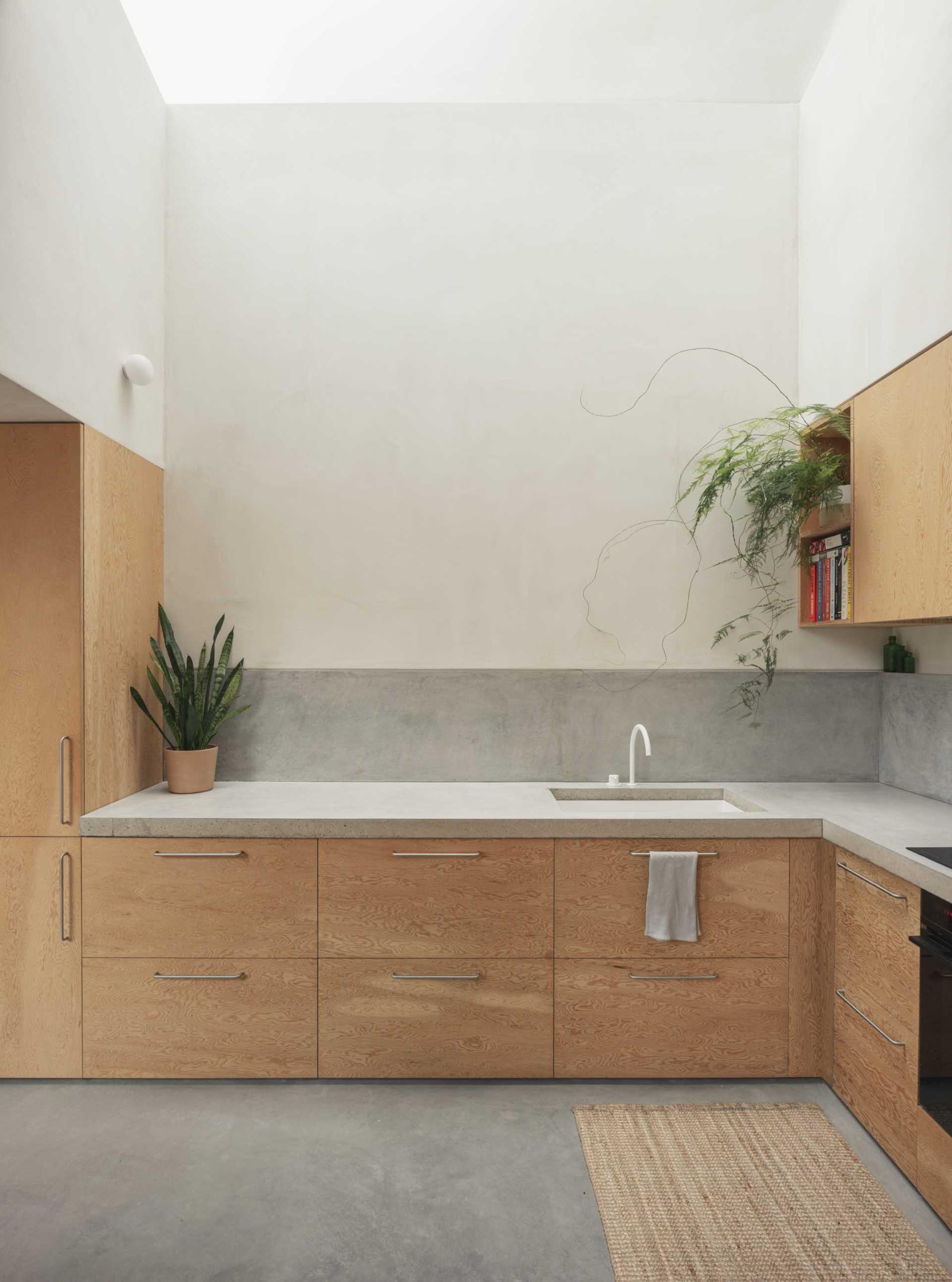A modern kitchen with deep Douglas Fir wood cabinets, and undermount sink, and a concrete countertop.