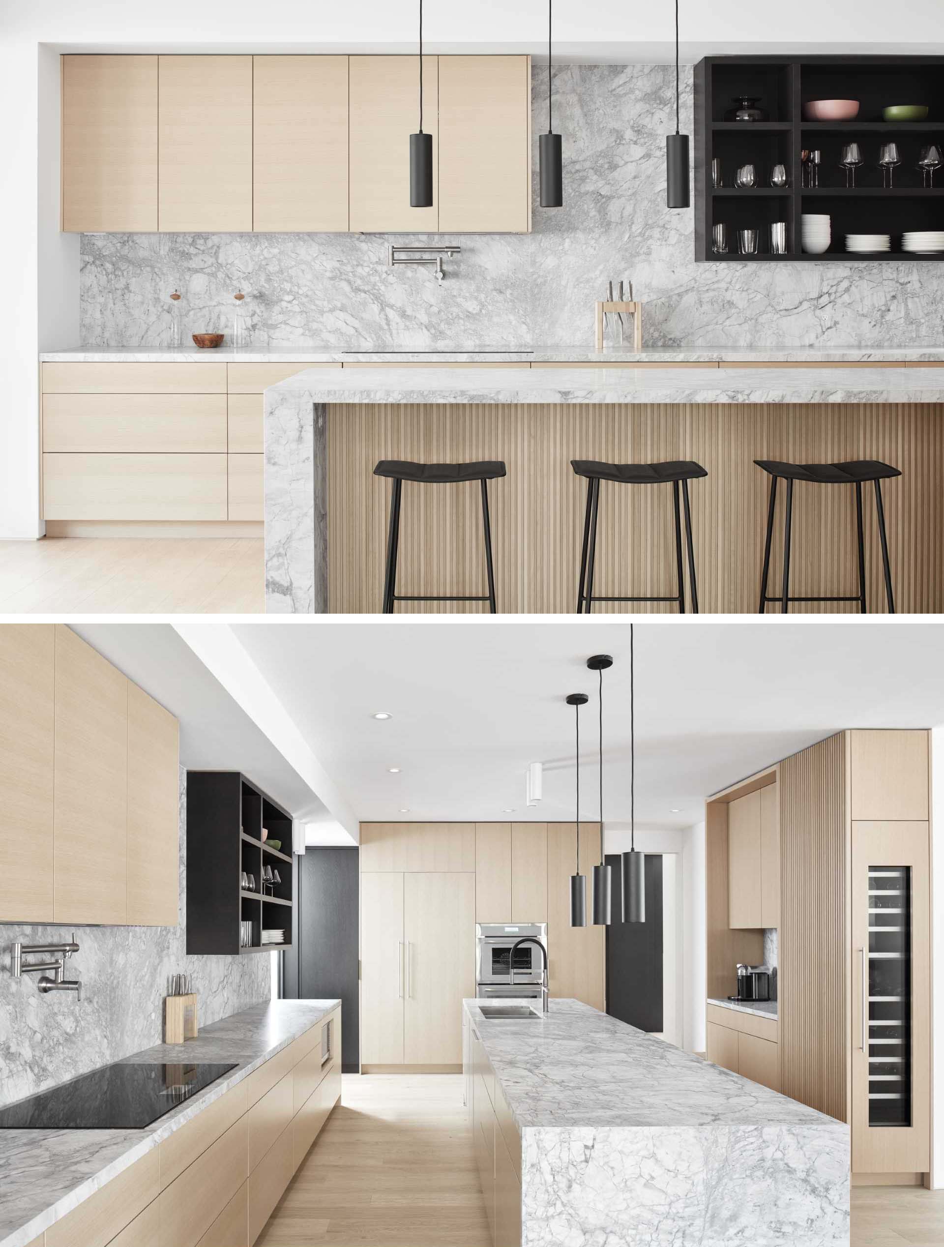 Natural oak and grey quartz have also been used in the kitchen, however this time, black has been used as an accent with the inclusion of minimalist pendant lights, stools, and upper shelves.