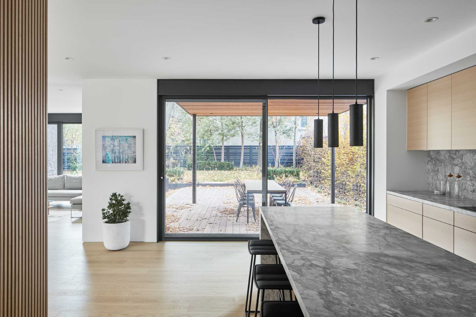 A modern kitchen has a large sliding glass door that opens to a covered patio.