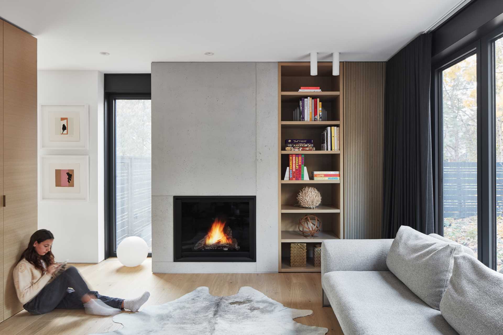 A modern family room a gas-fueled fireplace and built-in bookshelf.