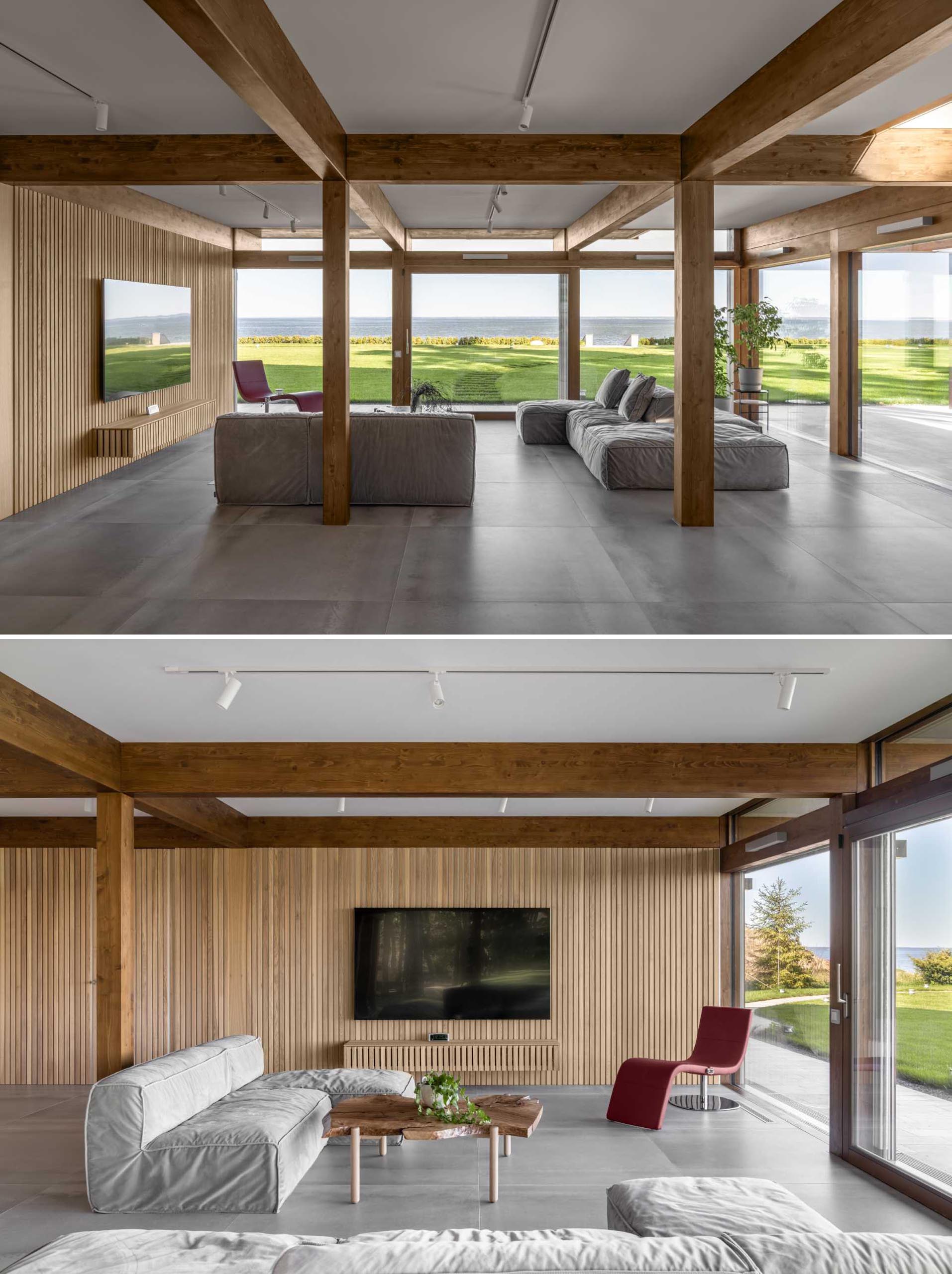 In this living room, a wood slat accent wall acts as a backdrop for the television, and complements the exposed wood and beam structure of the home.