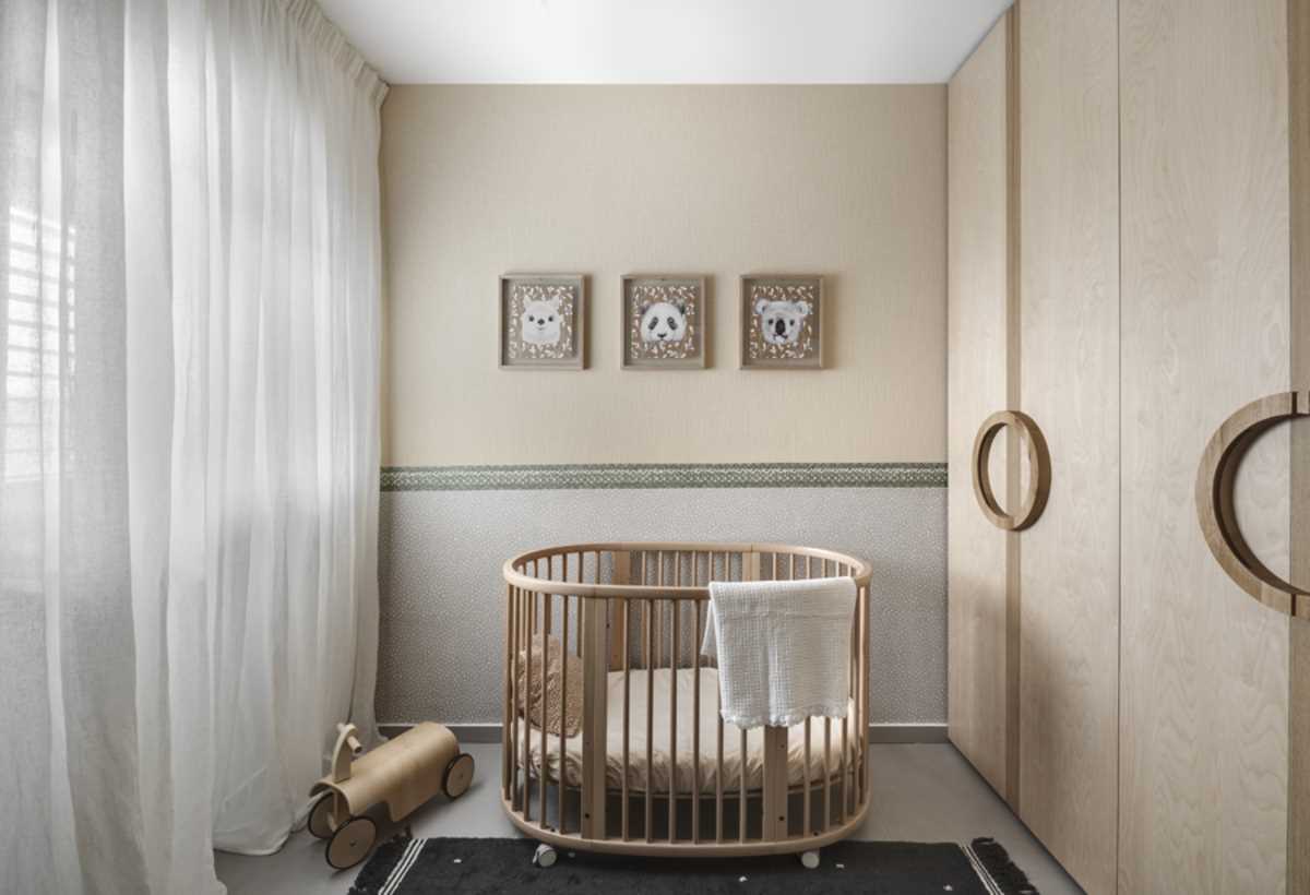 In this nursery, neutral colors have been used to create a calm atmosphere. The floor-to-ceiling closets have door handles that make a circle when closed.