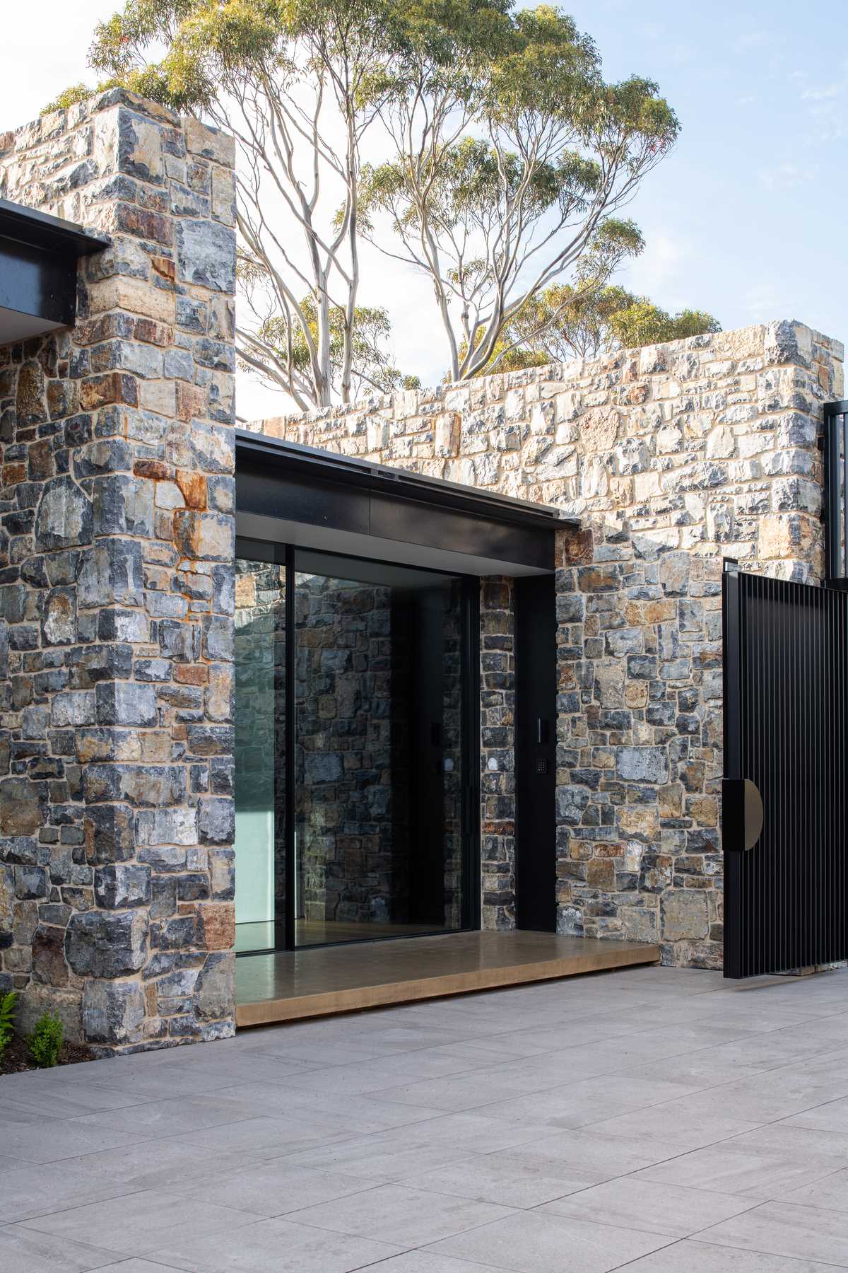 A modern house with stone walls and steel accents.