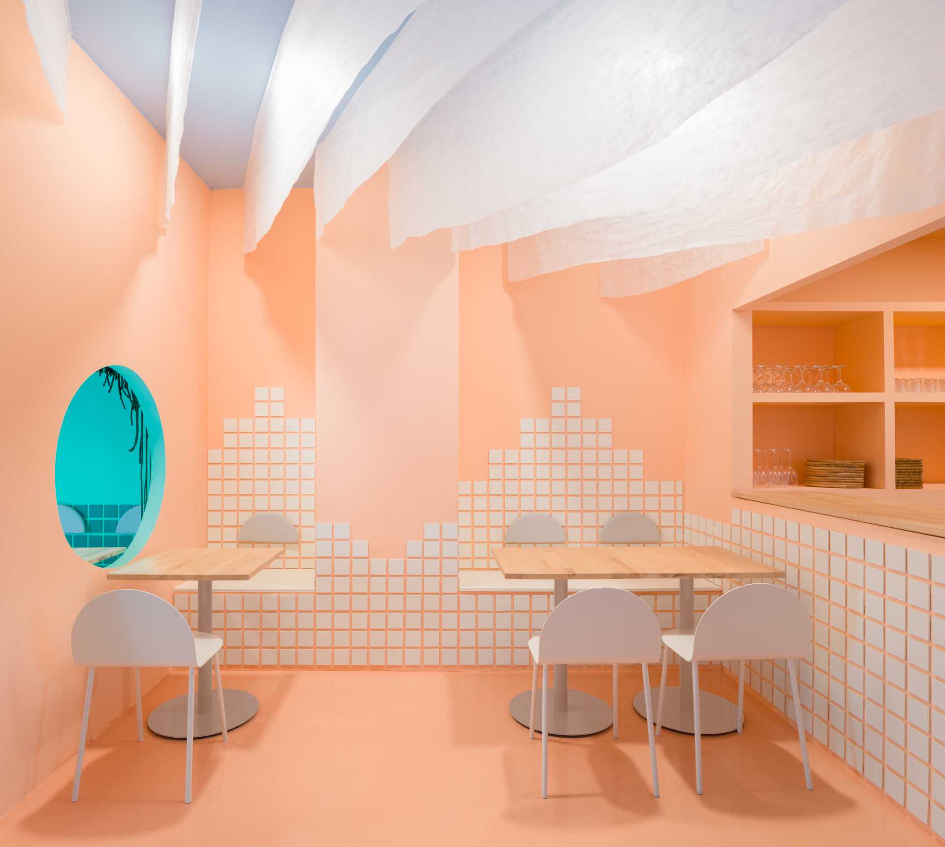 A modern restaurant with sandy colored walls and a ceiling that recreates a blanket of clouds.