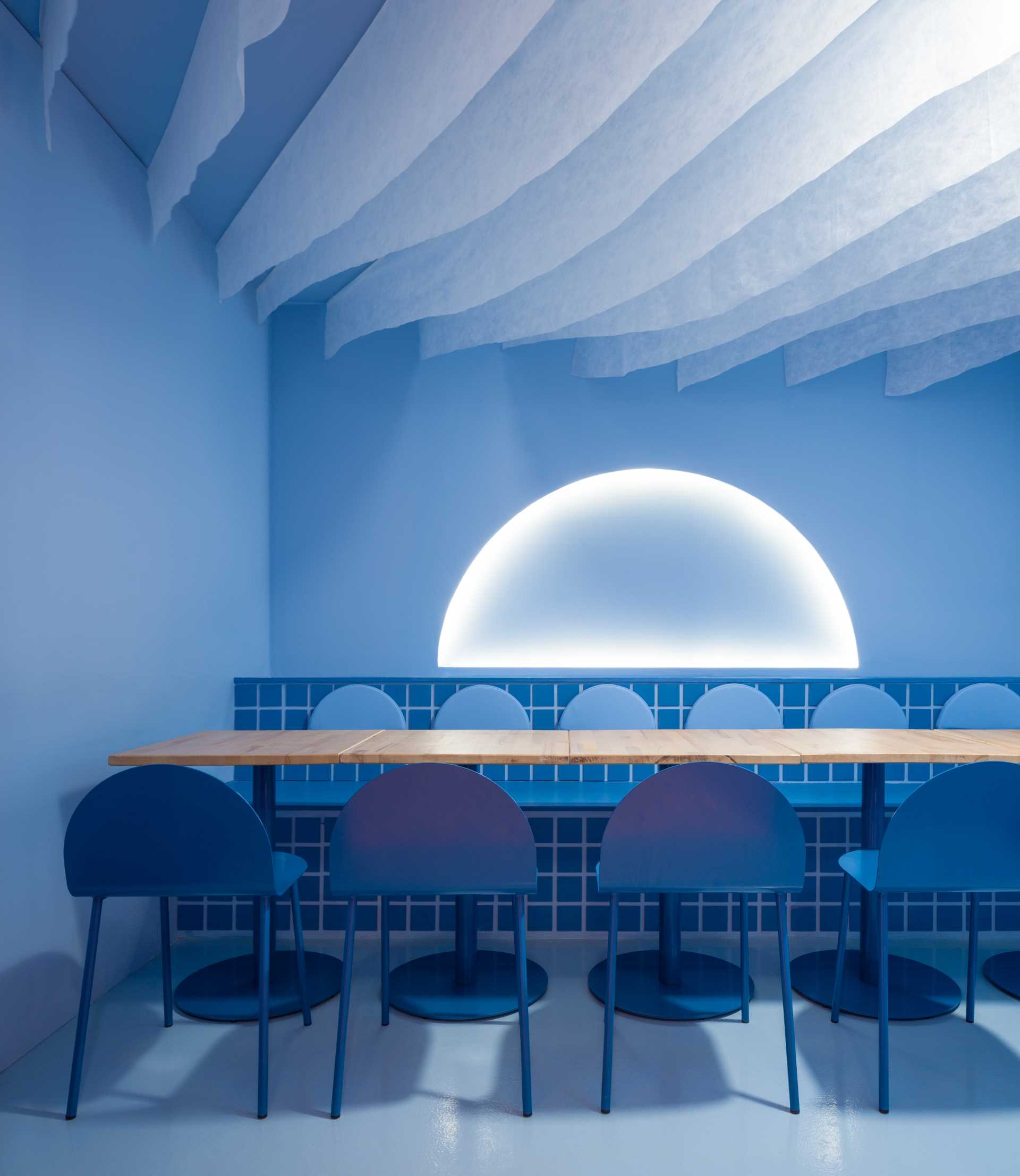 A bold blue restaurant interior designed to allow people to eat in the "moonlight".