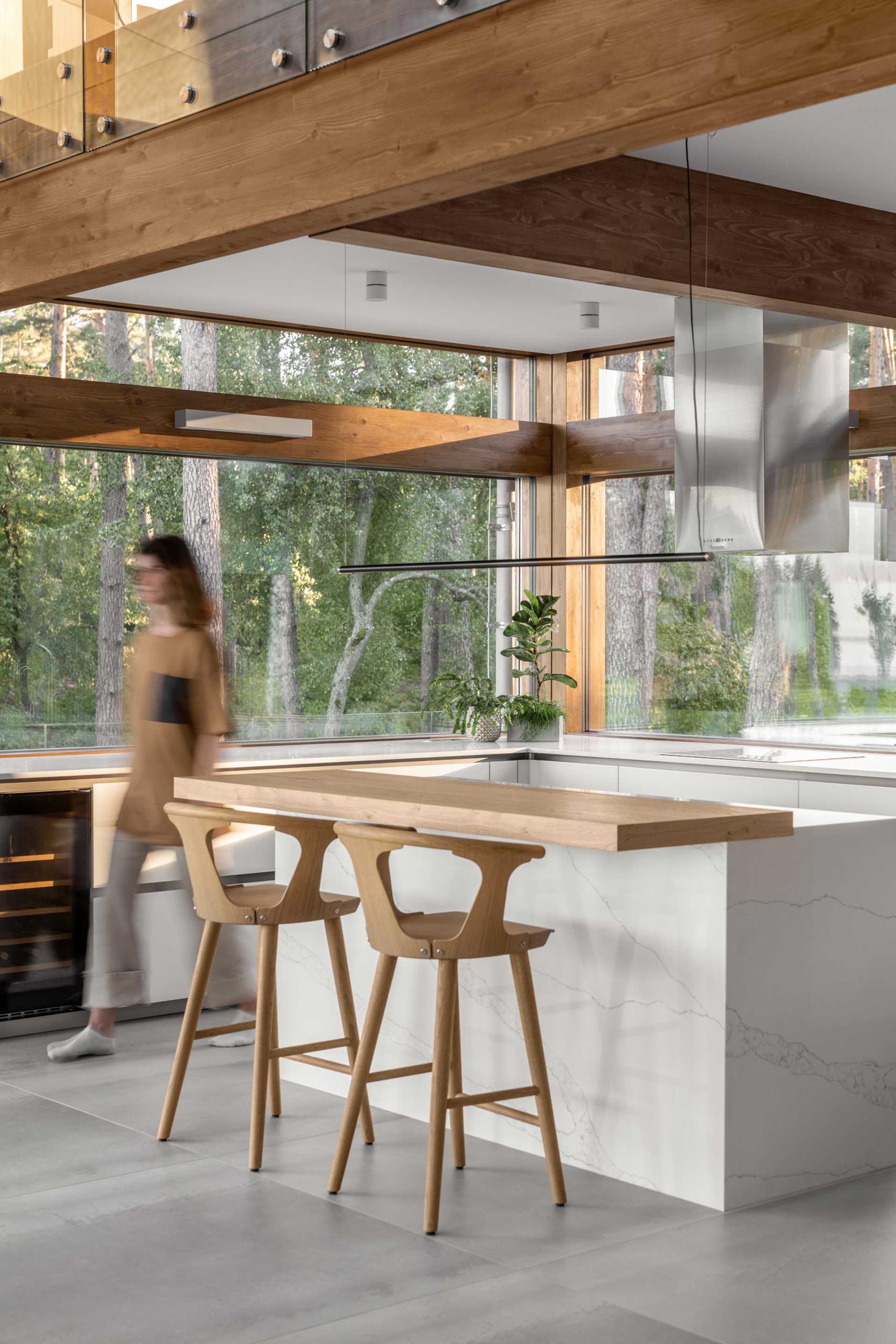 A modern kitchen with an island that includes a wood bar.