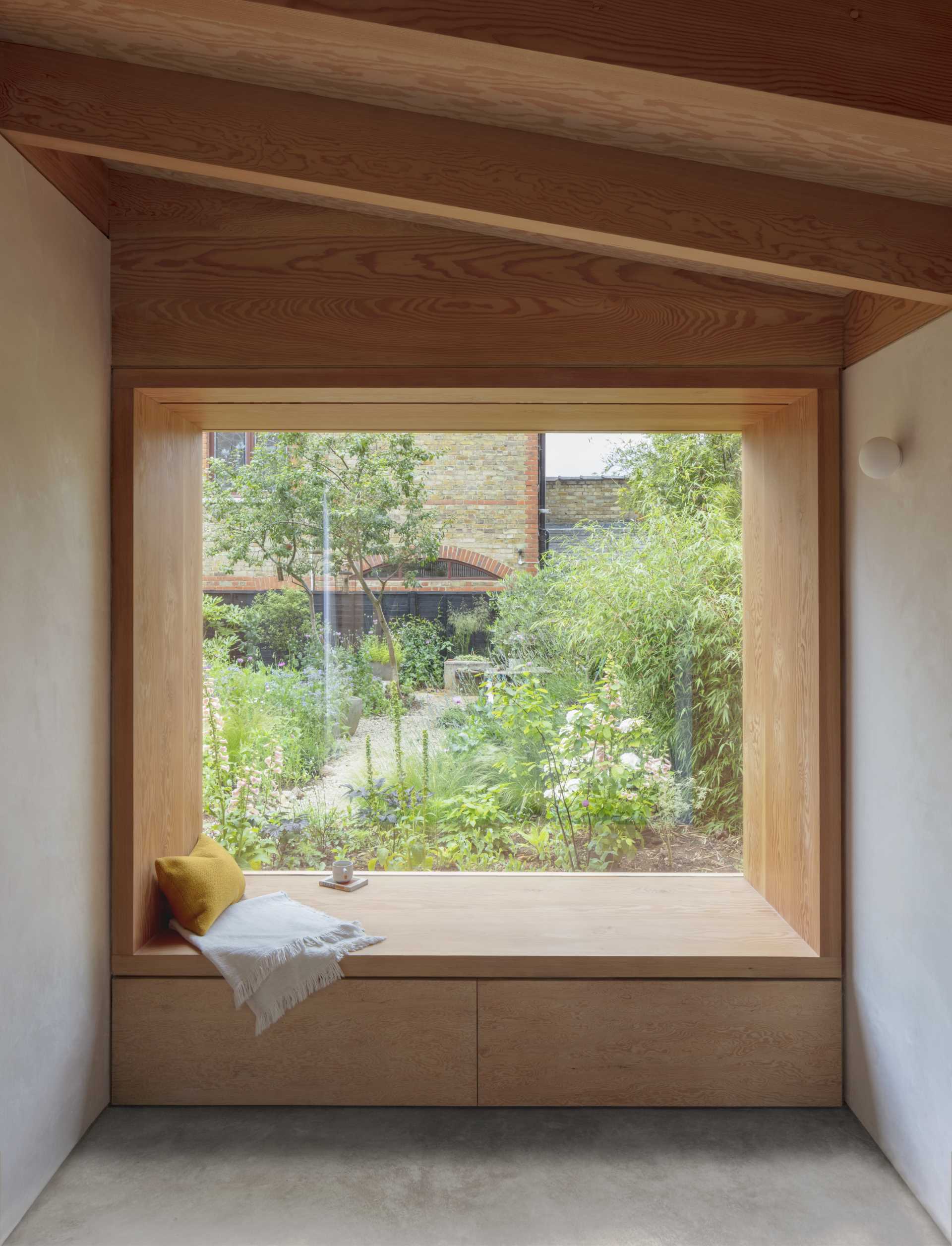 A large wood framed picture window with a deep built-in bench.