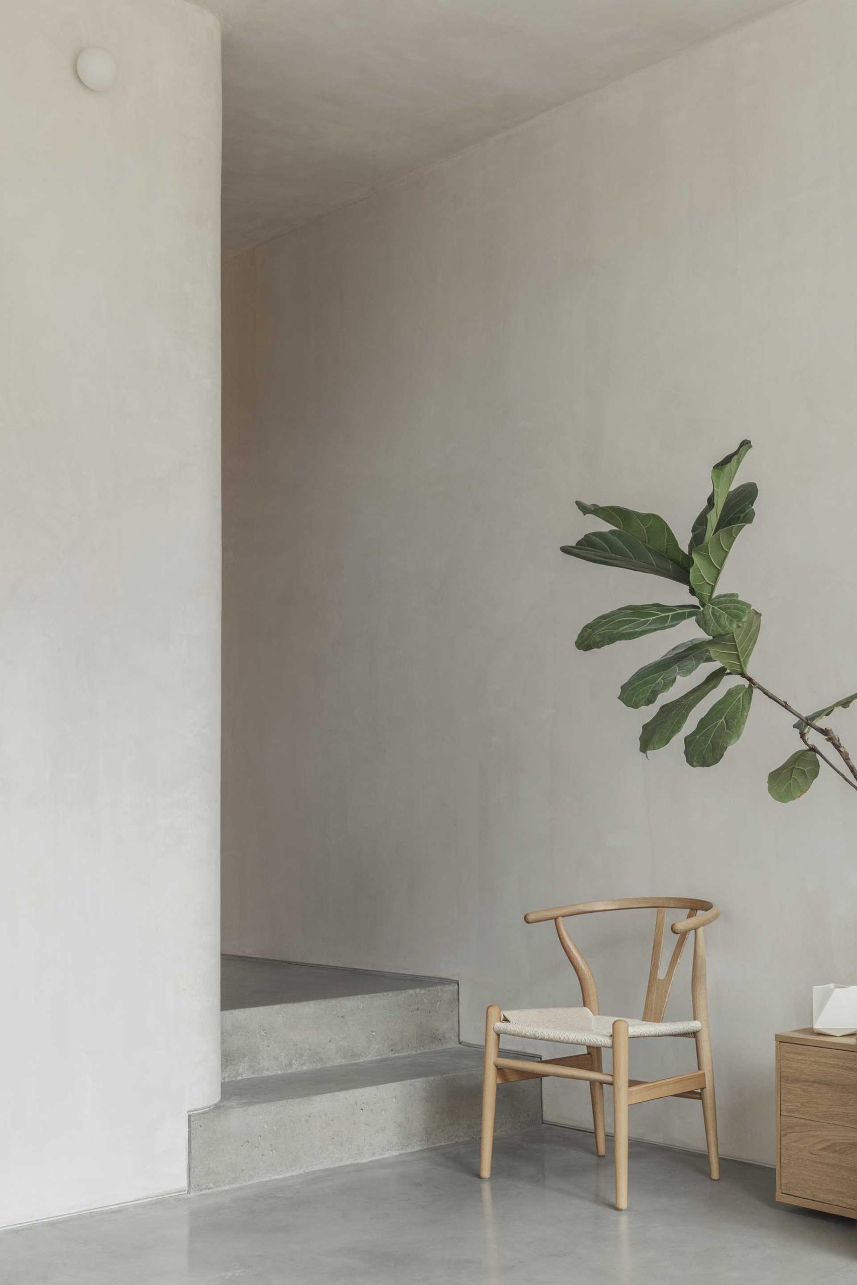 A modern interior with polished concrete floors and stairs, and lime plaster walls.