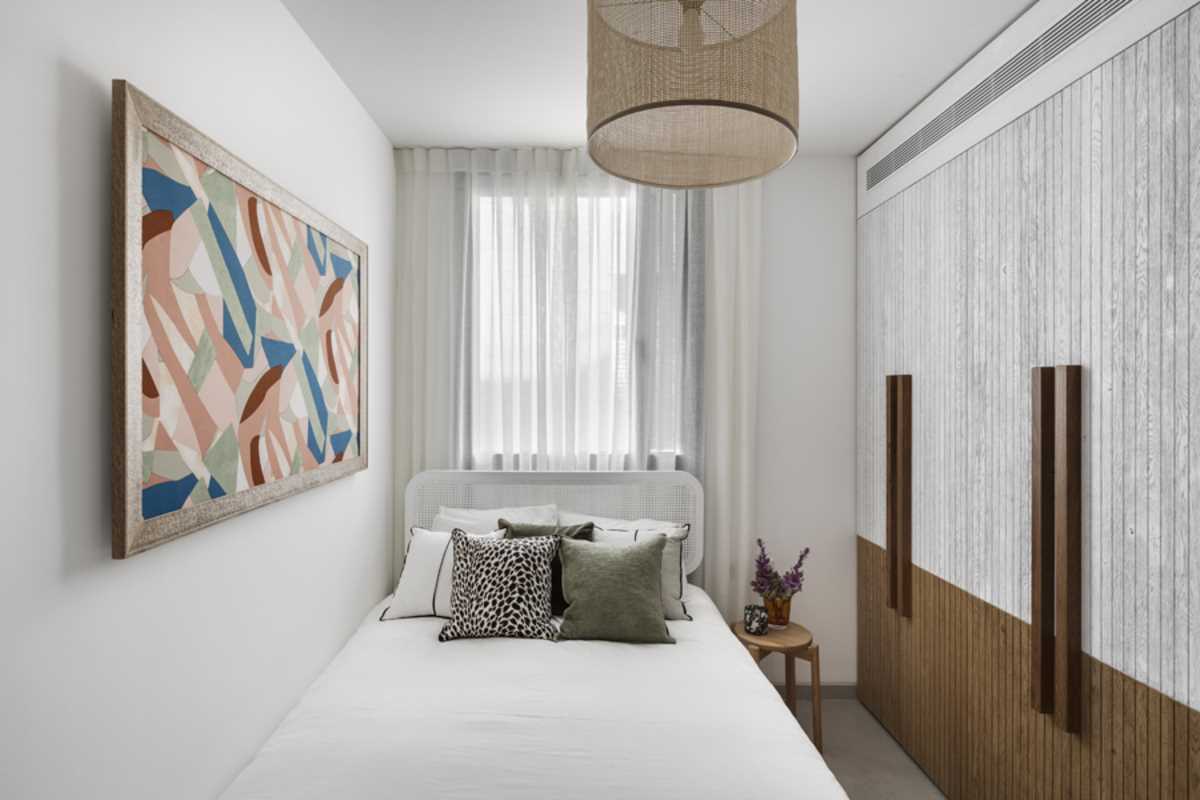 In this small bedroom, the palette has been kept minimal, with wall art providing color.