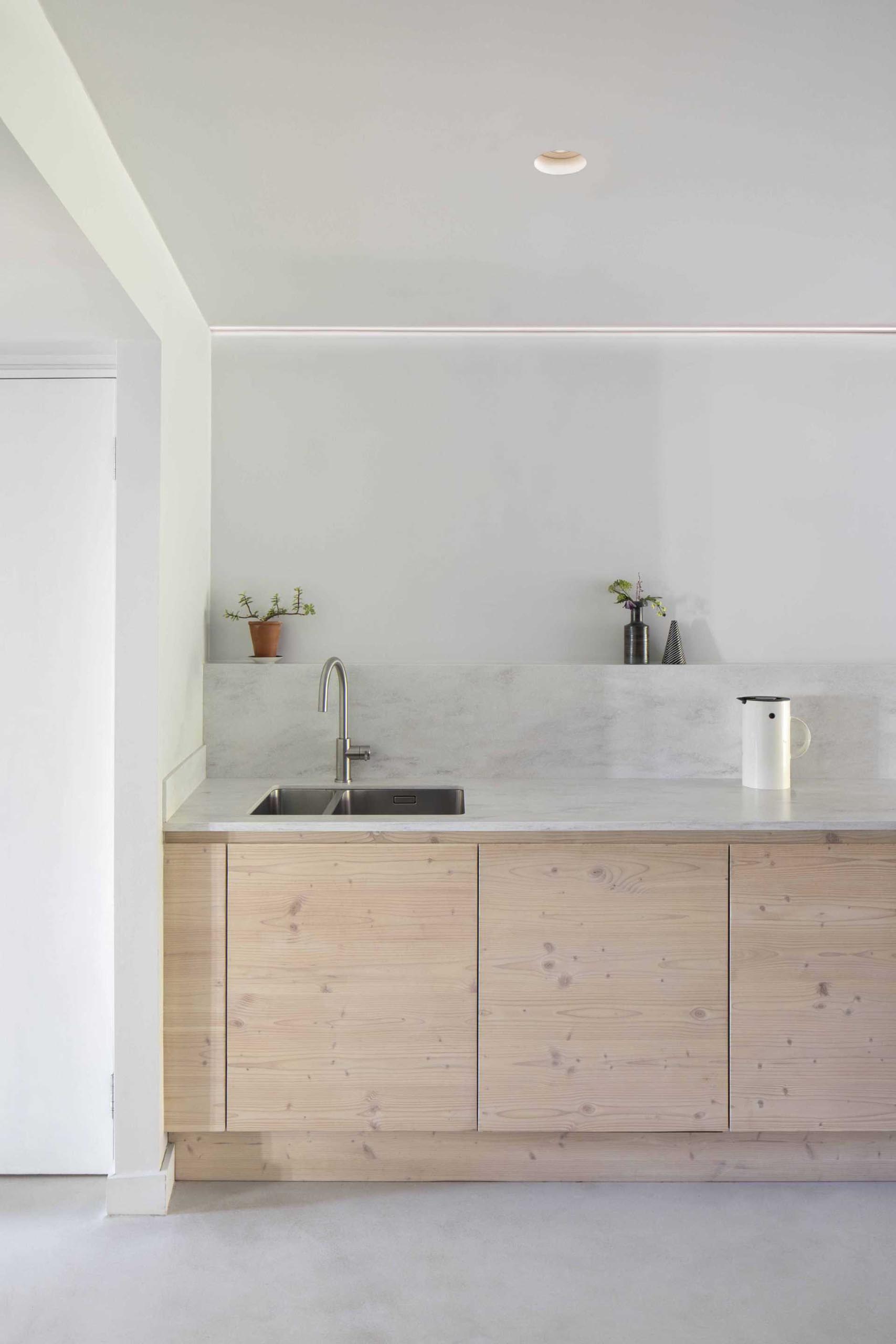 A contemporary galley kitchen with minimalist wood cabinets.