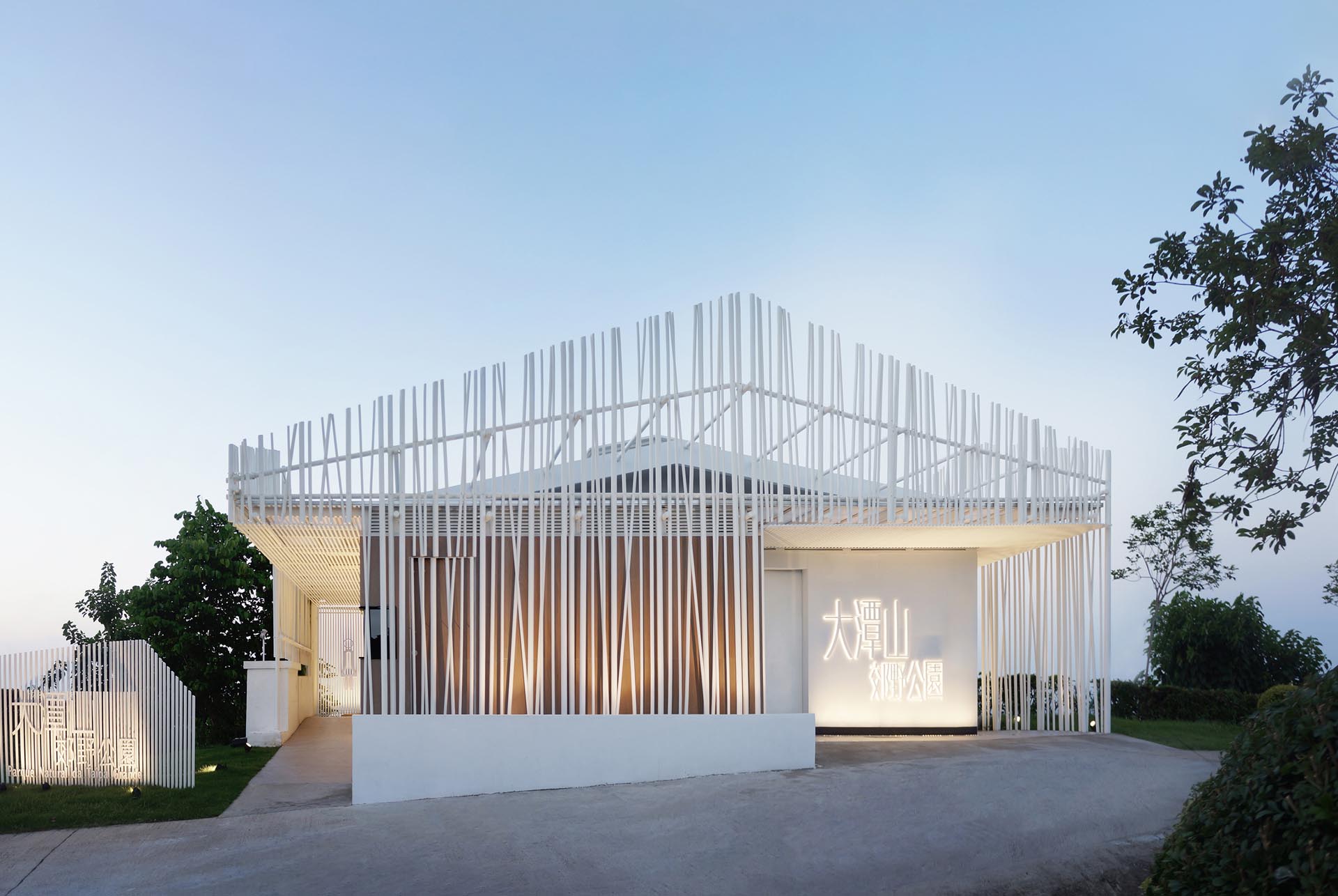 The facade of the Bamboo Pavilion is a re-interpretation of bamboo scaffolding, with hundreds of white aluminum tubes arranged in a staggered manner, surrounding the renovated structure forming a translucent shell that blends in with nature.