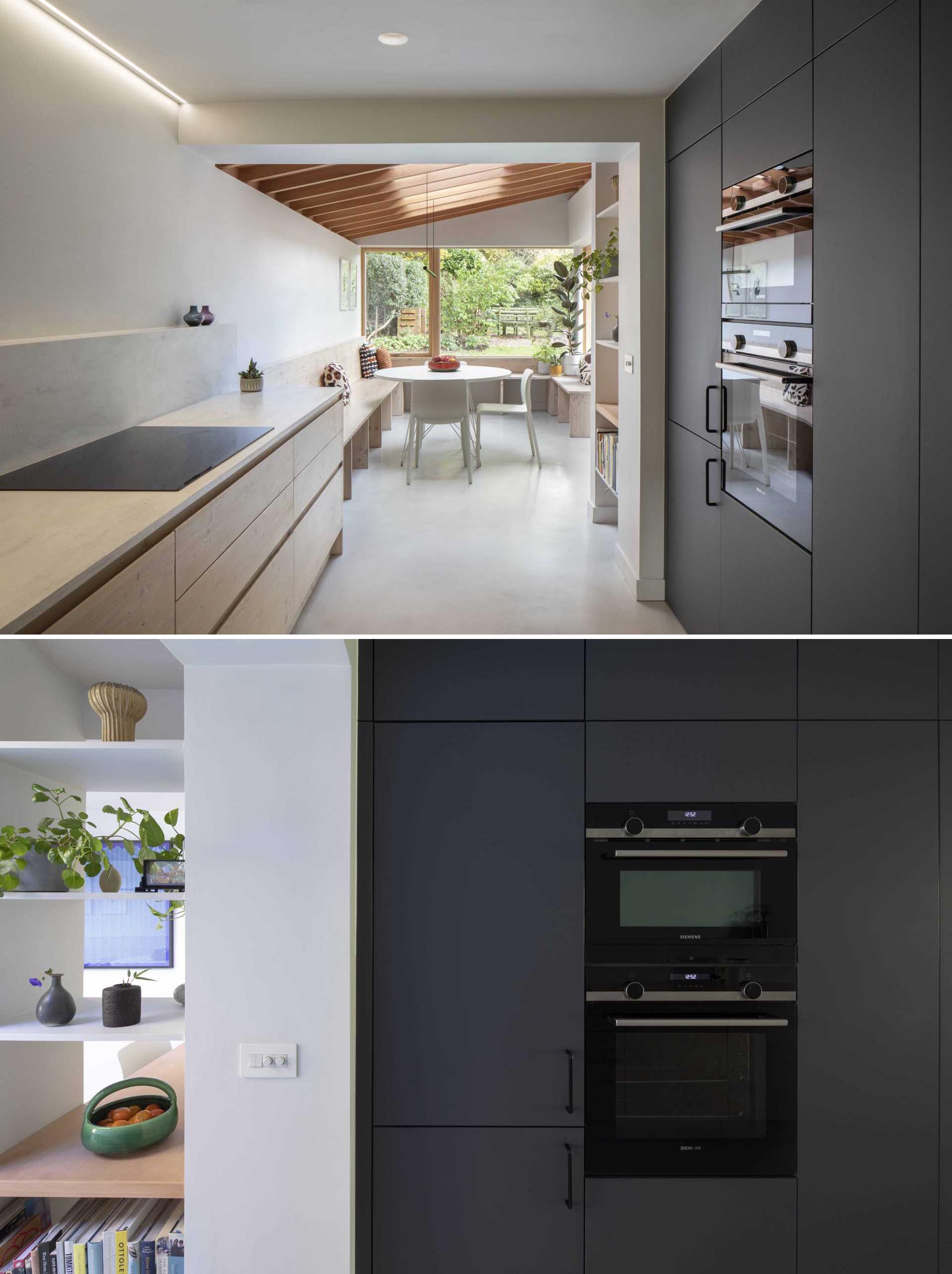 A modern galley kitchen with matte black and wood cabinets.