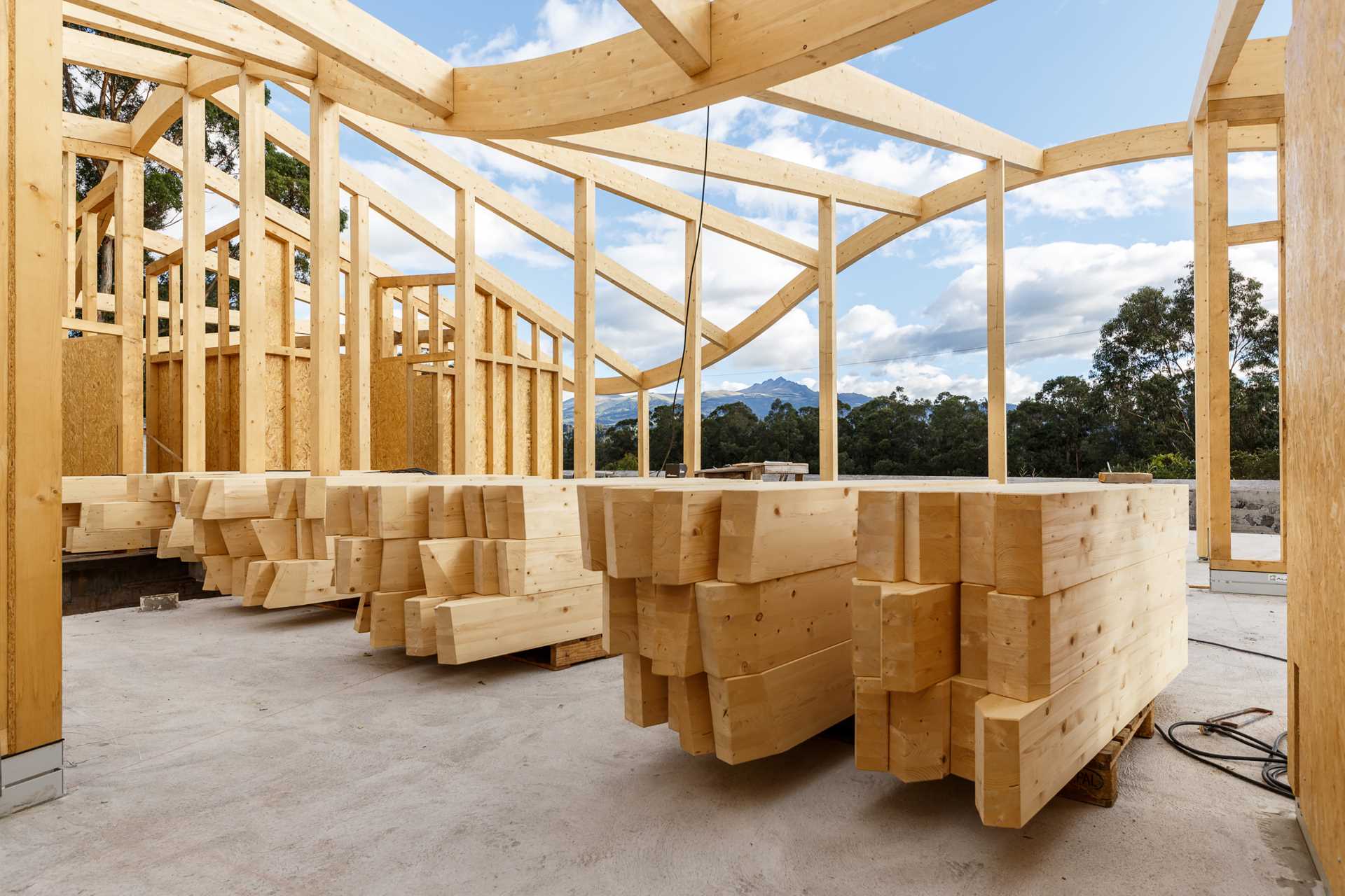 The construction of a wood house with a wavy roof.