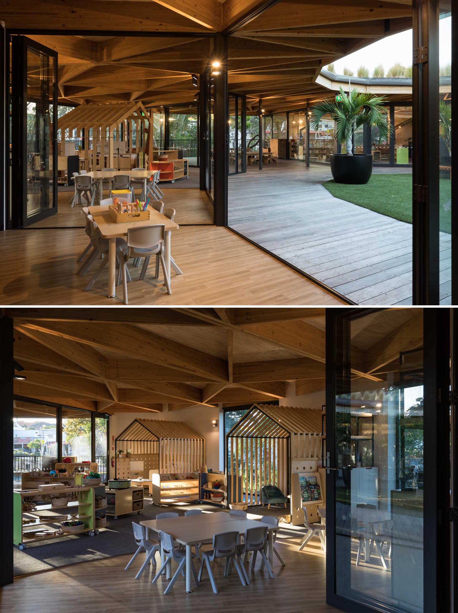 Floor-to-ceiling glass walls surround playrooms at an early learning centre and open to a playground.