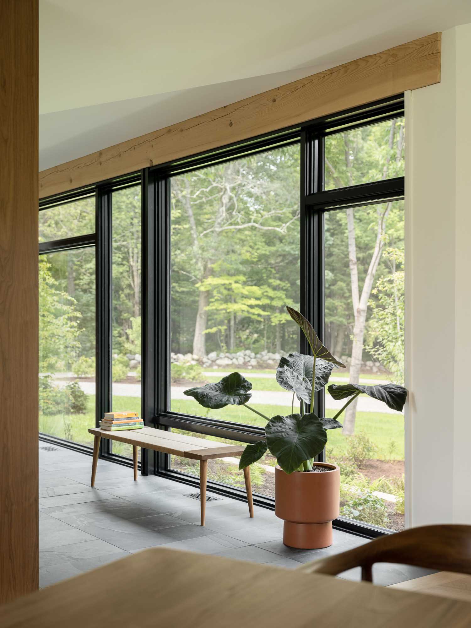 A wall of black-framed windows fills the entryway with natural light.
