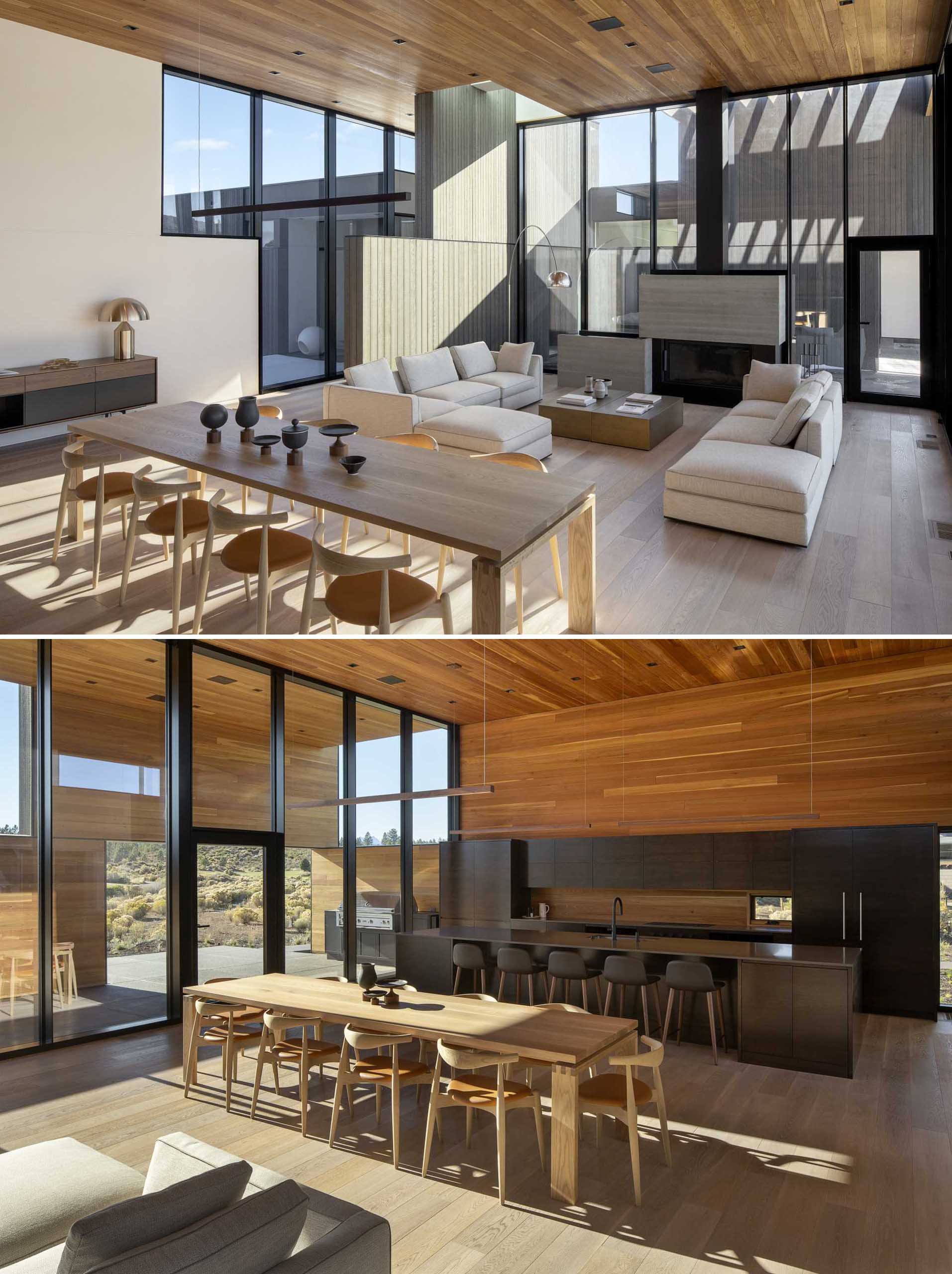 In this modern house with high ceilings, there are tall windows are featured on multiple walls, while the living room includes a wood burning fireplace.