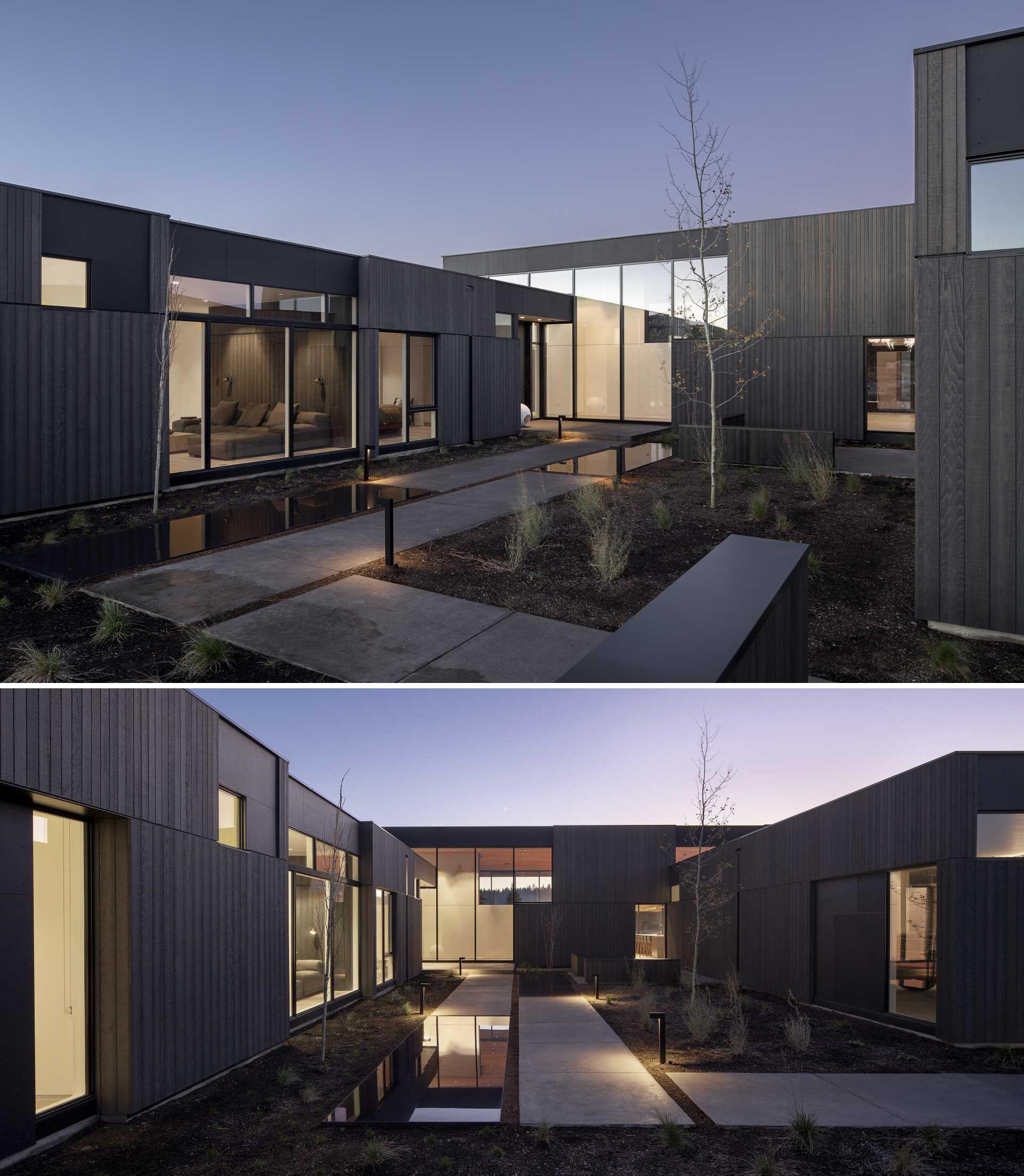 A path leads between the different volumes of this modern house to guide visitors to the front door.