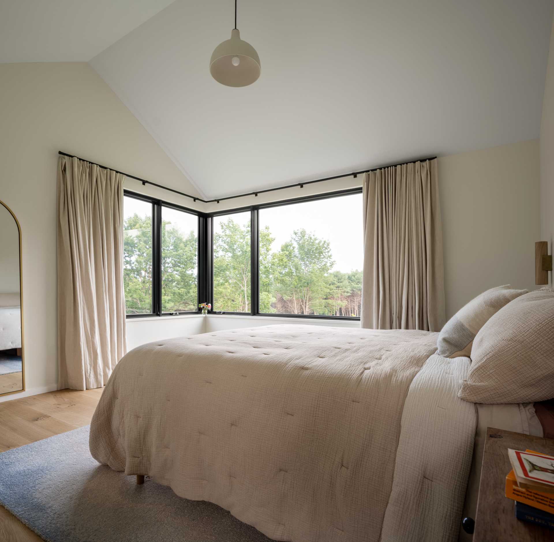 In this modern bedroom, light furnishings and curtains keep the room light and relaxing.